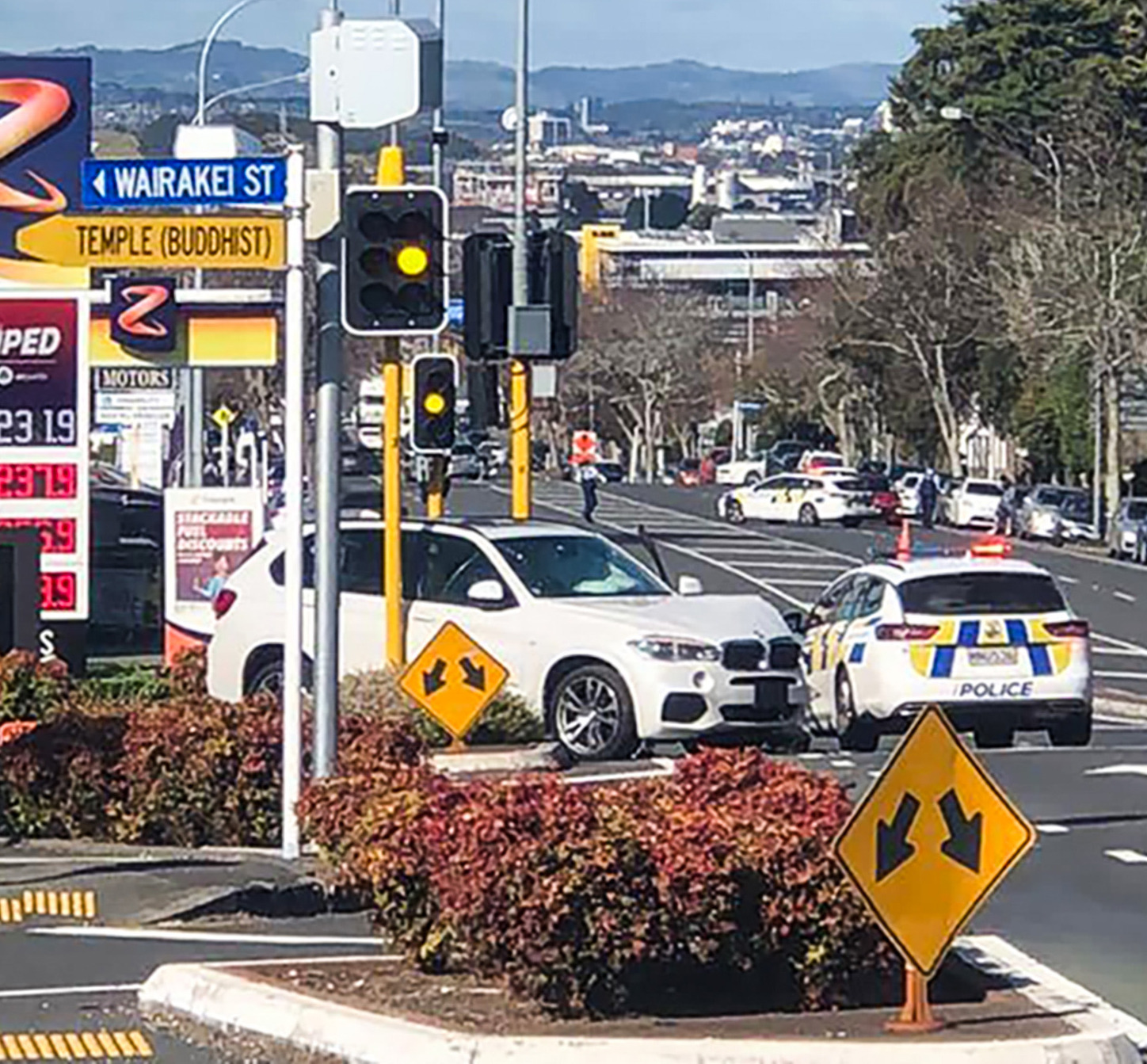 Armed police stand guard near a crashed BMW stolen from a car dealership on Great South Rd Greenlane. A man was arrested after several gunshots were fired. Photo / Supplied
