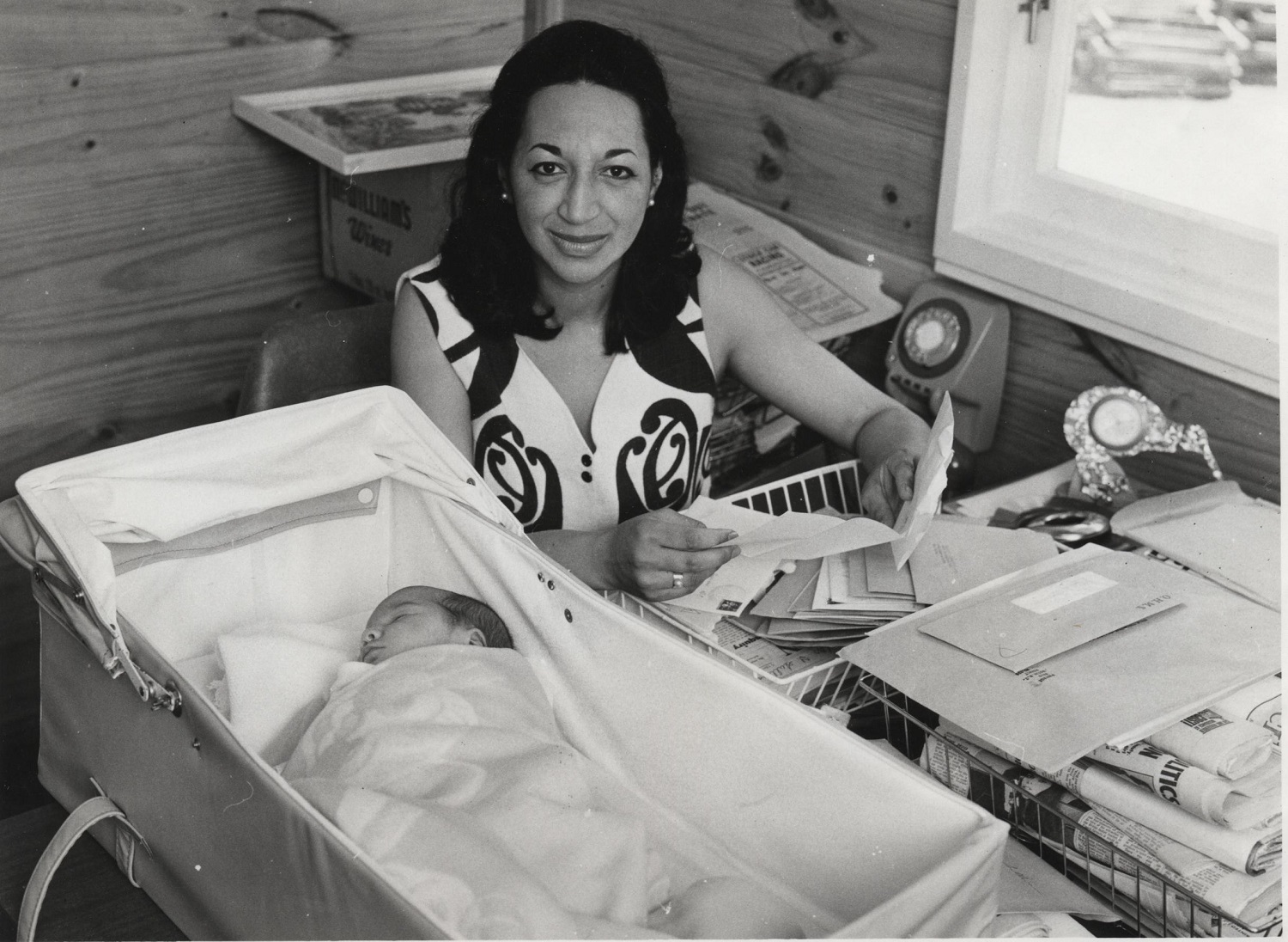 Whetu Tirikatene-Sullivan at work c.1970 with her daughter May-Ana wearing a dress featuring a print by Sandy Adsett. Photo / Neale McMillan courtesy of the Parliament Collection