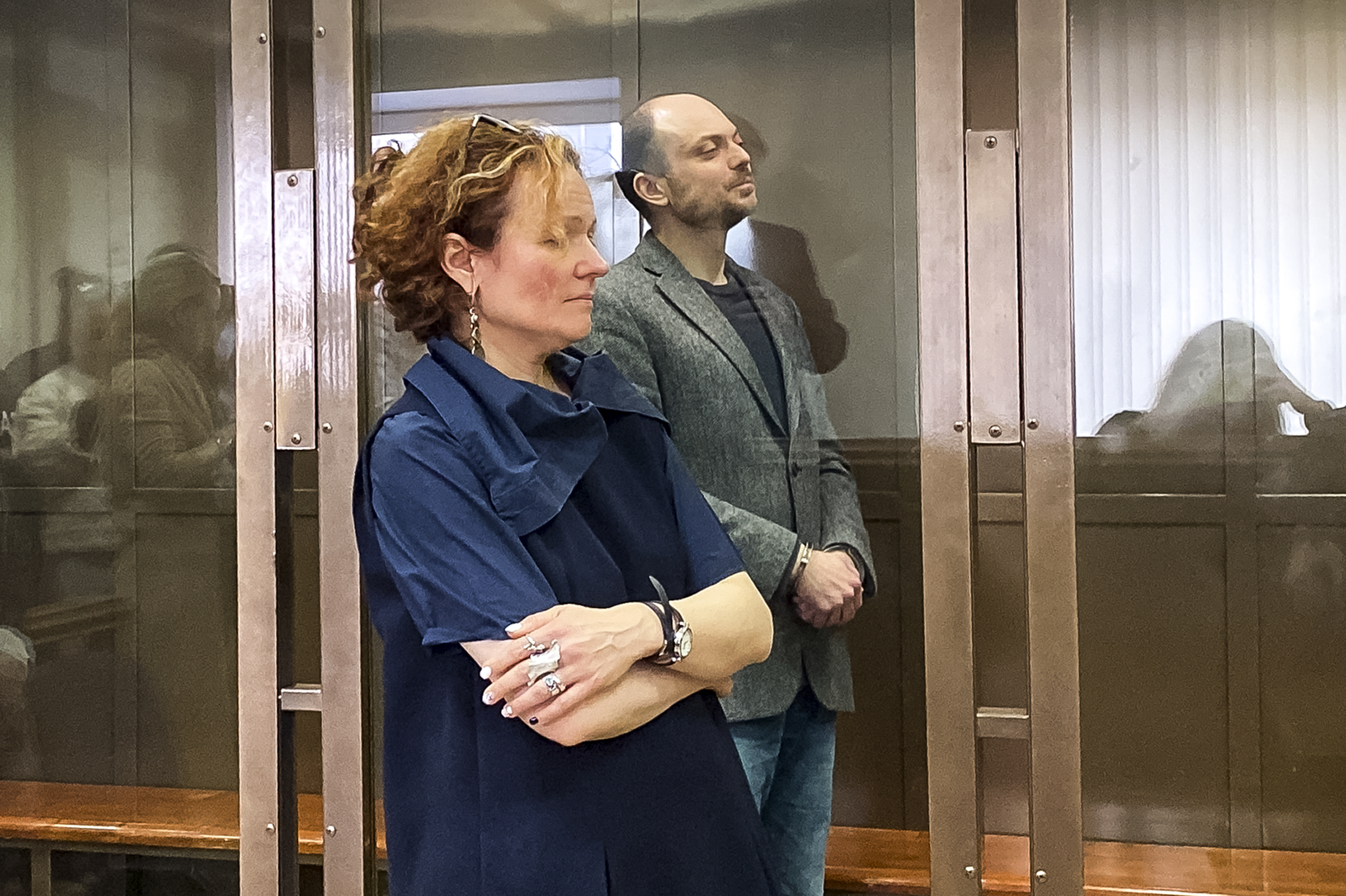 Russian opposition activist Vladimir Kara-Murza stands in a class cage and his lawyer, Maria Eismont as they listen to the verdict in a courtroom at the Moscow City Court. Photo / The Moscow City Court via AP