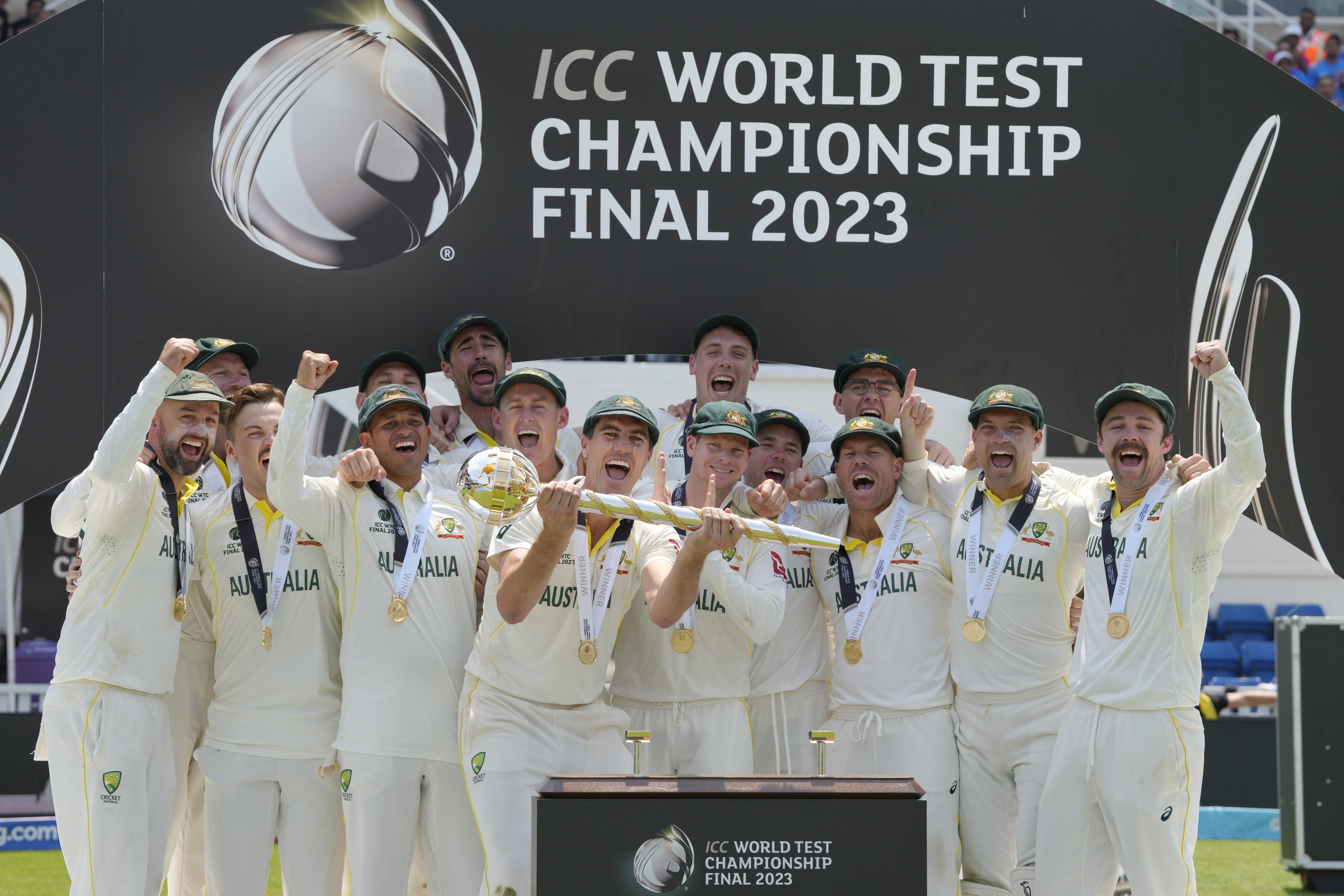 The Australian team celebrate as captain Pat Cummins holds the winners trophy during the victory ceremony for the ICC World Test Championship Final. Photo / AP