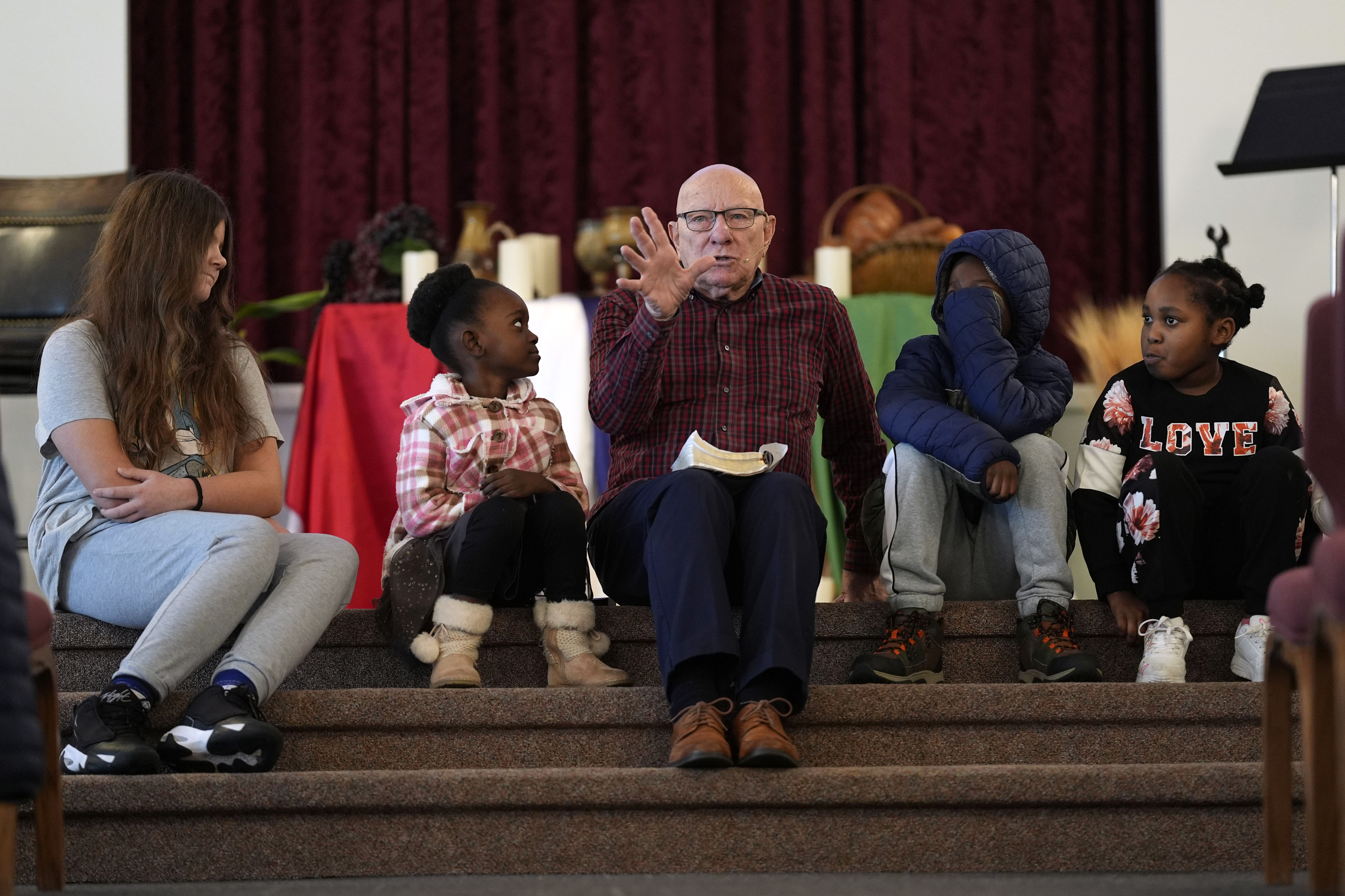 Pastor Charles Hundley, center, talks with young congregation members. Photo / AP