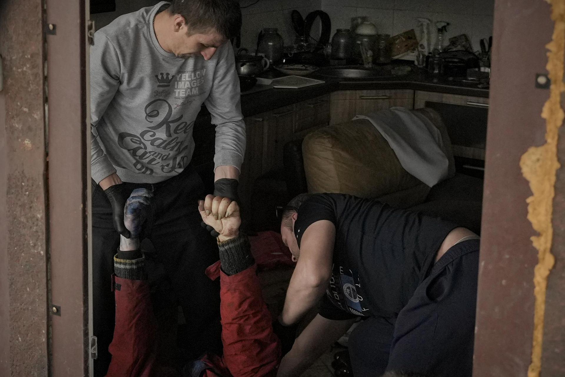 Municipal workers remove the body of a man who died from a house in Bucha, Ukraine, Thursday, April 7, 2022. Photo / AP