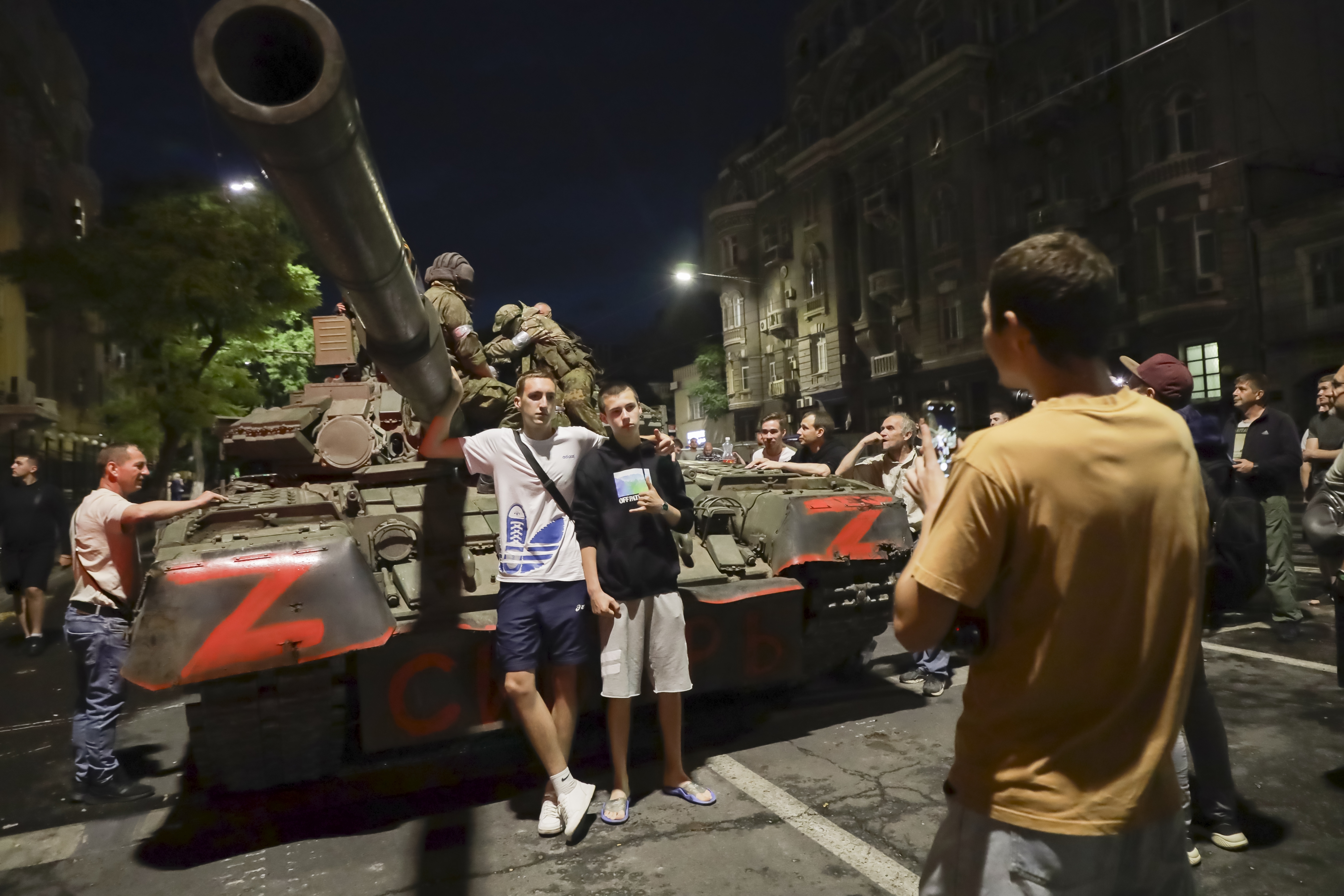 Men from the Wagner Group military company sit on a tank, as locals pose for a photo prior to the group leaving Rostov-on-Don. Photo / AP Photo