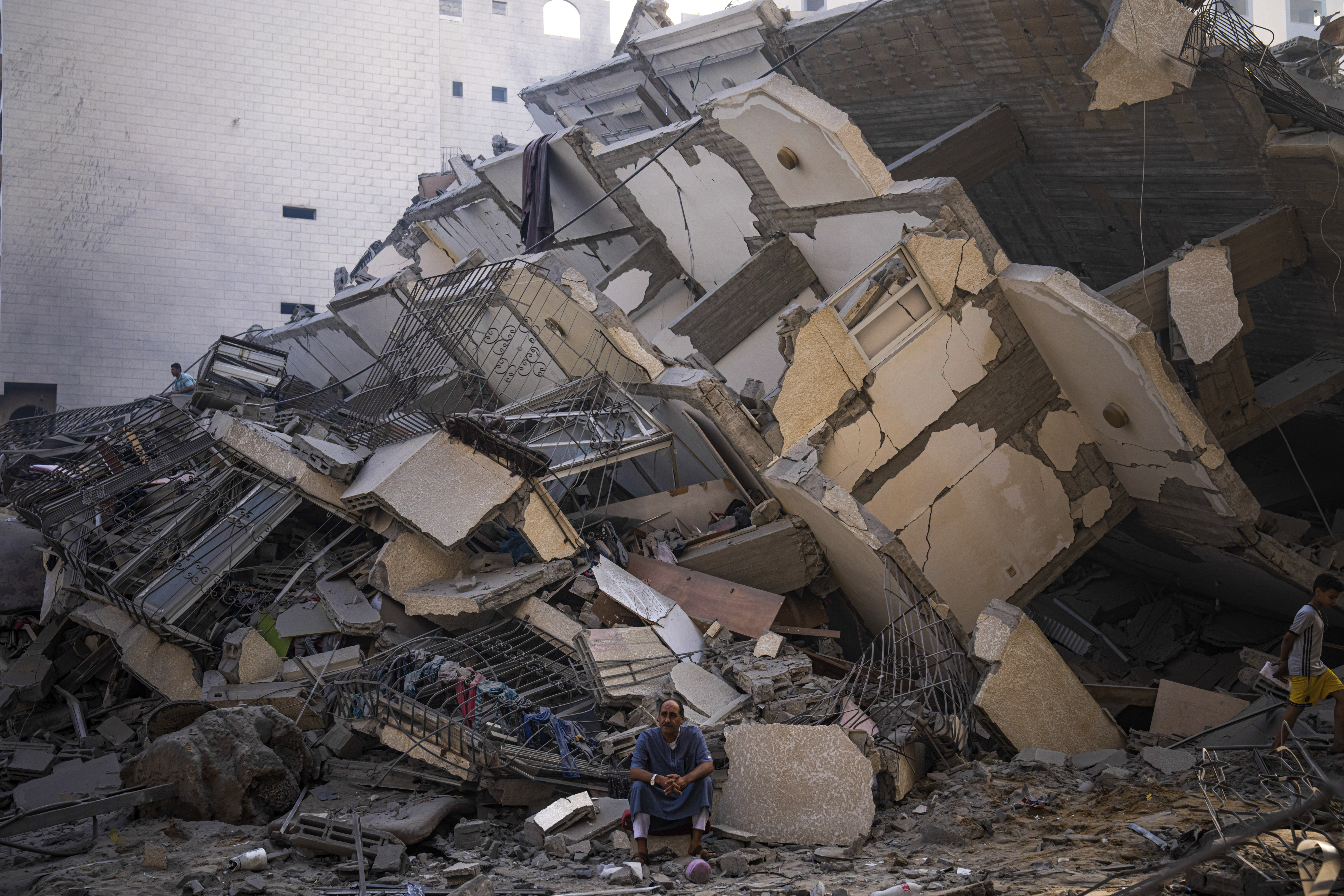 FILE - A Palestinians man sits in the rubble of a building after it was struck by an Israeli airstrike, in Gaza City, Sunday, Oct. 8, 2023. Photo / AP
