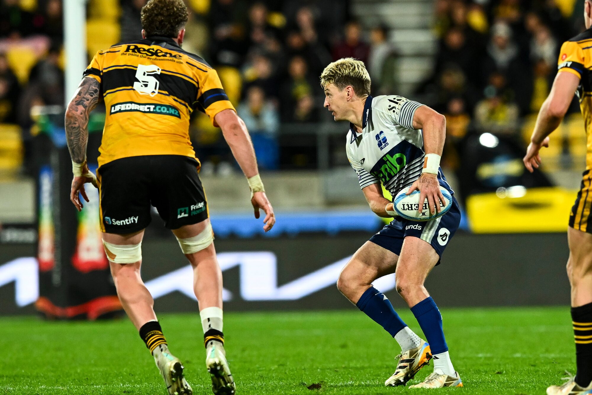 Beauden Barrett, of the Blues, looks to pass the ball as Hurricanes lock Warner Dearns approaches. Photo / Photosport 