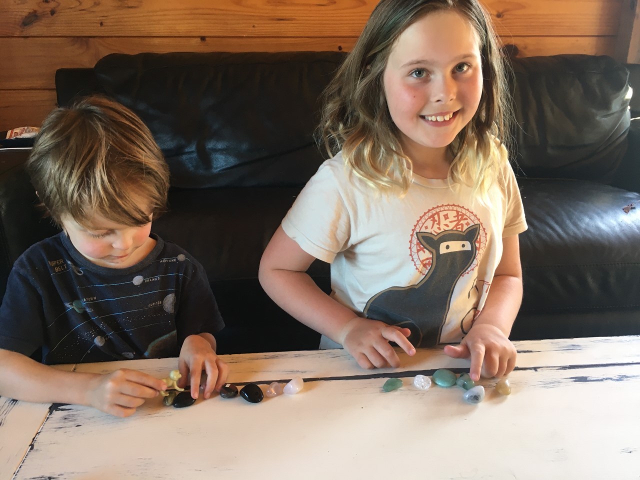 Holly Nightingale, 8, pictured (right) with 4-year-old brother Bastian, learns maths better with tactile objects such as small stones. Photo / Supplied