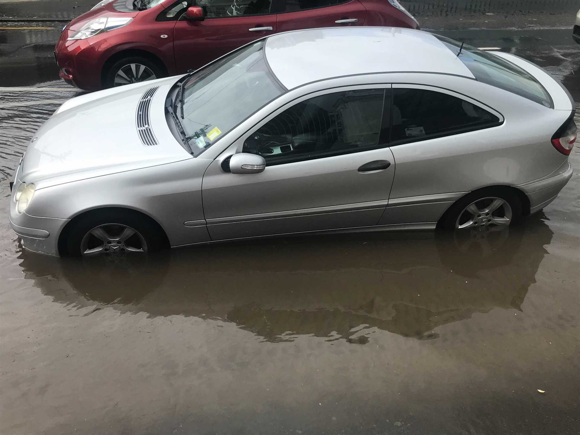 Water has reached halfway up the wheels of some parked cars. Photo / Katie Harris