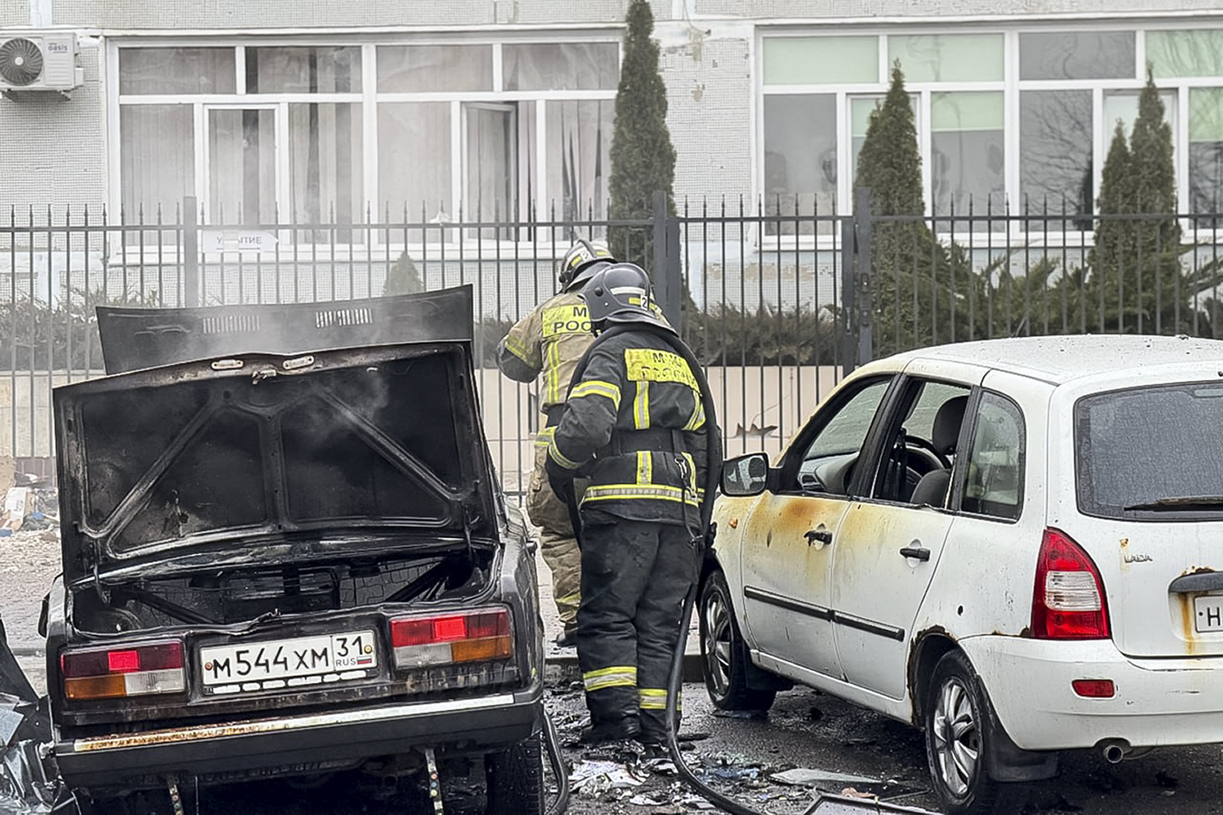 Emergency employees working by damaged and burned cars after shelling from the Ukrainian side, in Belgorod, Russia. Photo / Belgorod region governor Vyacheslav Gladkov telegram channel via AP