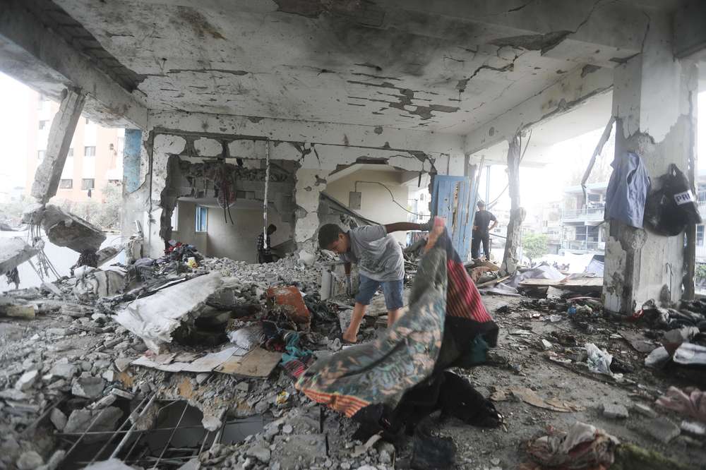 Palestinians look at the aftermath of the Israeli strike on a UN-run school that killed dozens of people in the Nusseirat refugee camp in the Gaza Strip. Photo / AP