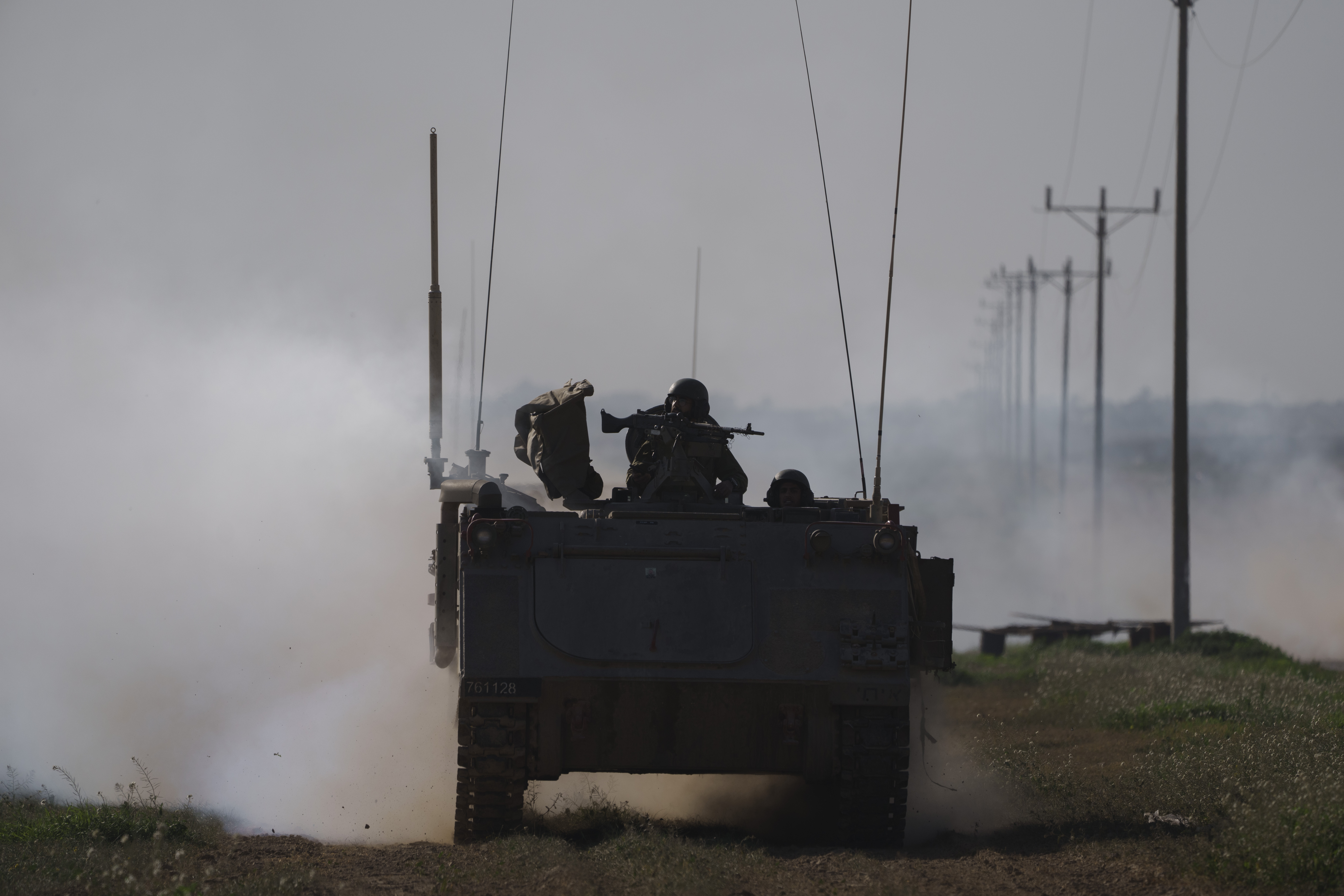 Israeli soldiers travel on an army armoured personnel carrier (APC) near the Israeli-Gaza border as smoke rises to the sky in the Gaza Strip, seen from southern Israel. Photo / AP