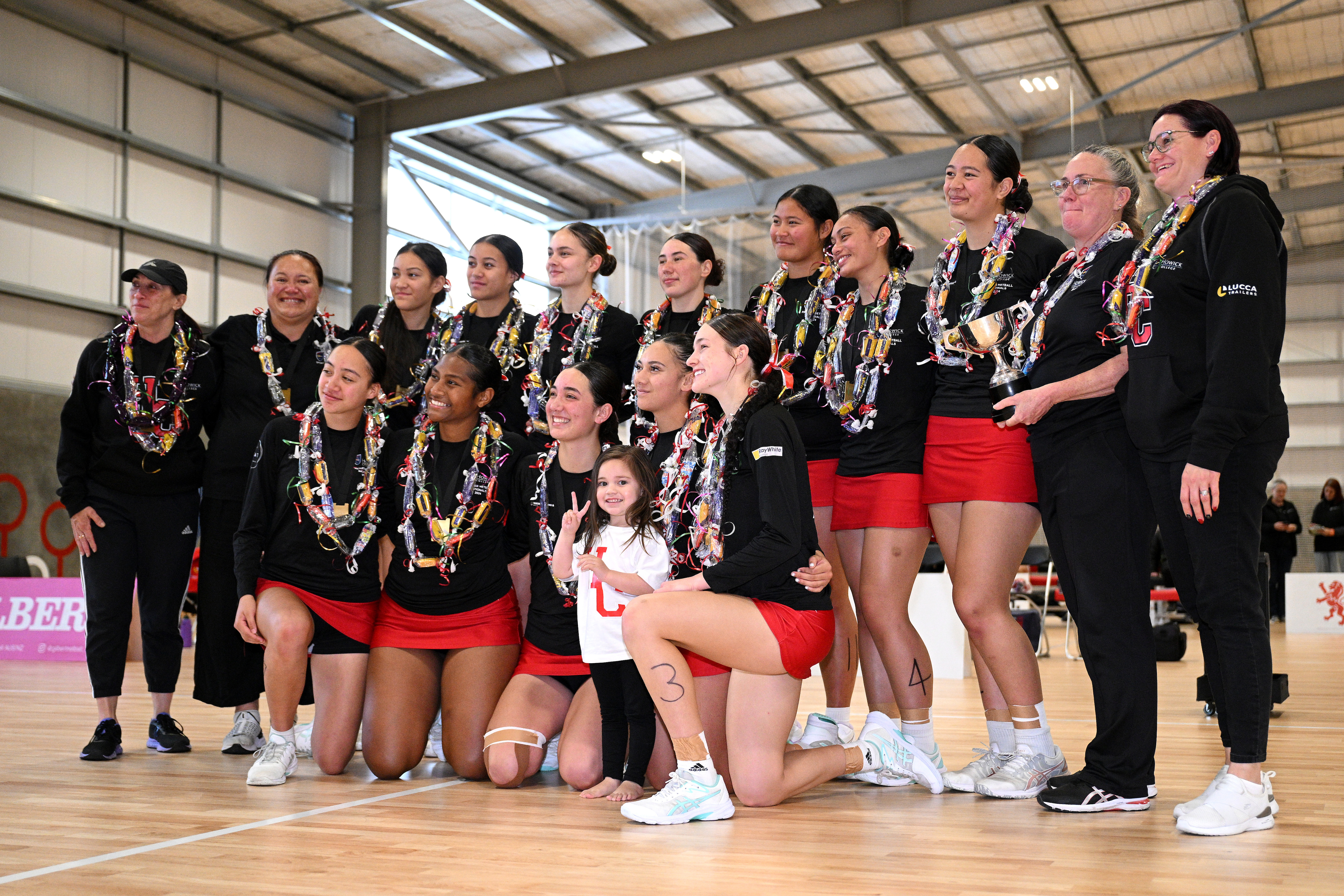 Undisputed! Howick College cap an unbeaten season with victory at the New Zealand Secondary Schools Netball Champs in Christchurch. Coach Adelita Sotutu (right) holds the trophy. Photo / Joe Allison, Michael Bradley Photography