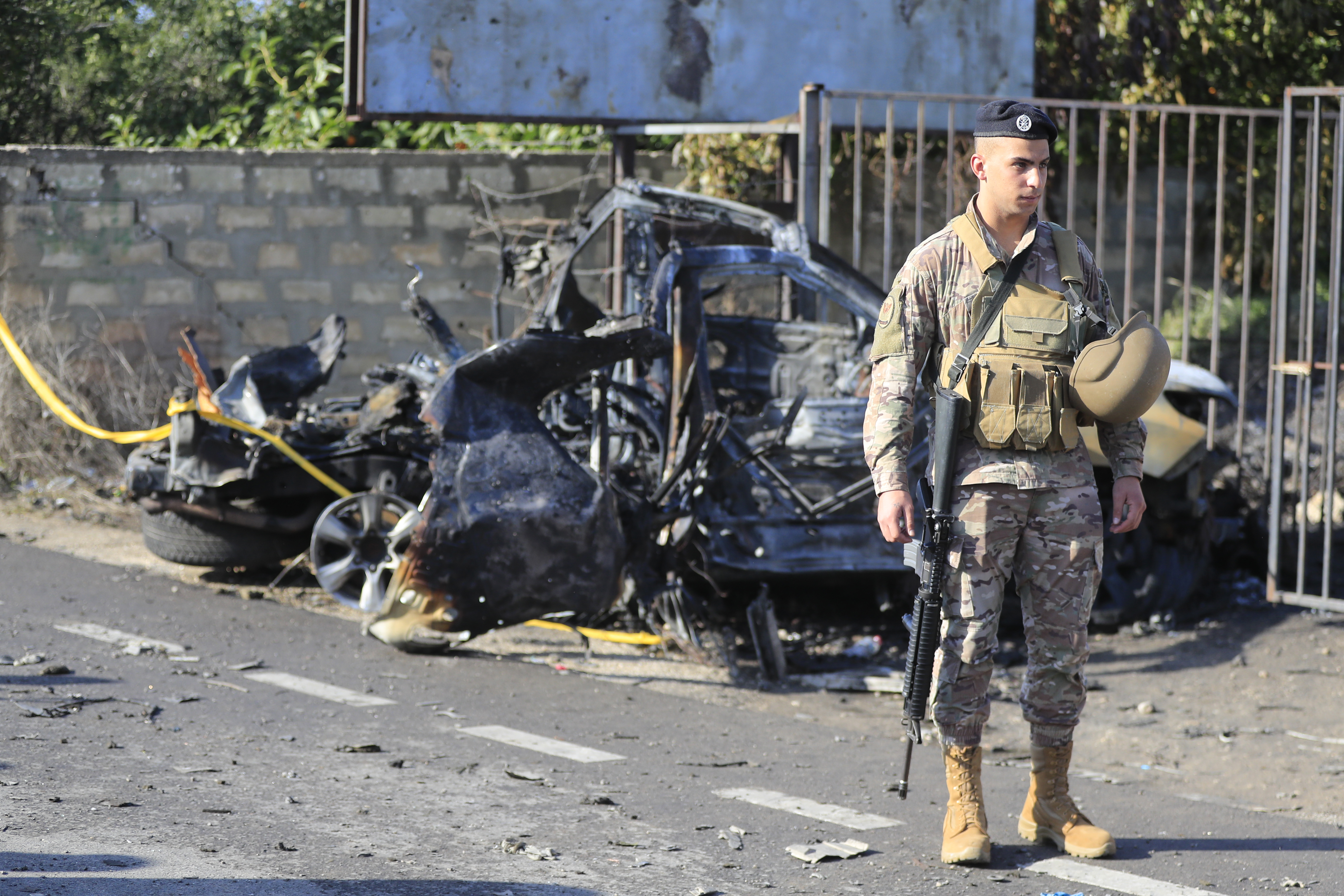 A Lebanese soldier stands next to a damaged car in the southern town of Bazouriyeh, Lebanon. Photo / AP