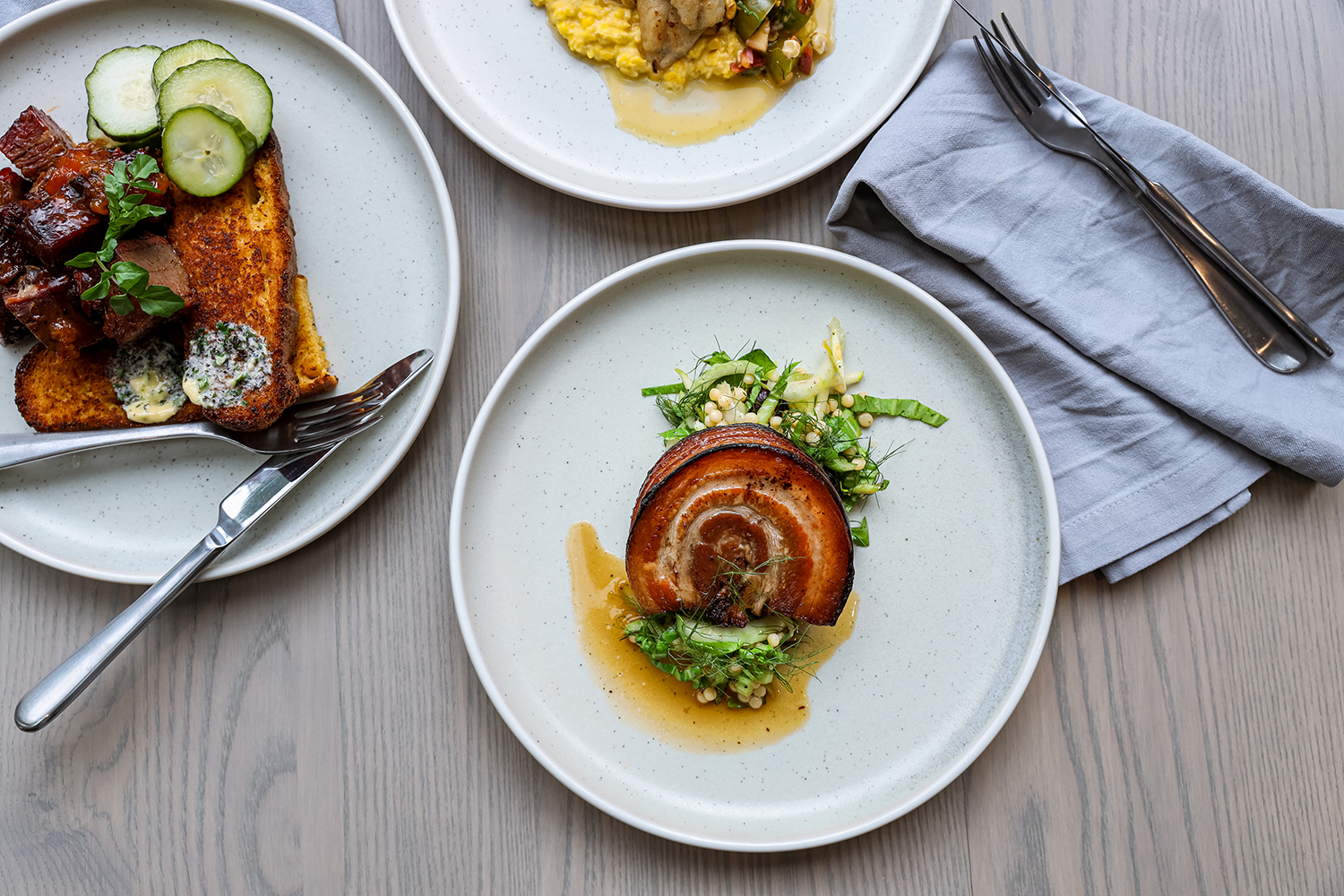 The pork belly with couscous and the slow-cooked brisket with cornbread and dill pickles at The Dishery. Photo / Supplied