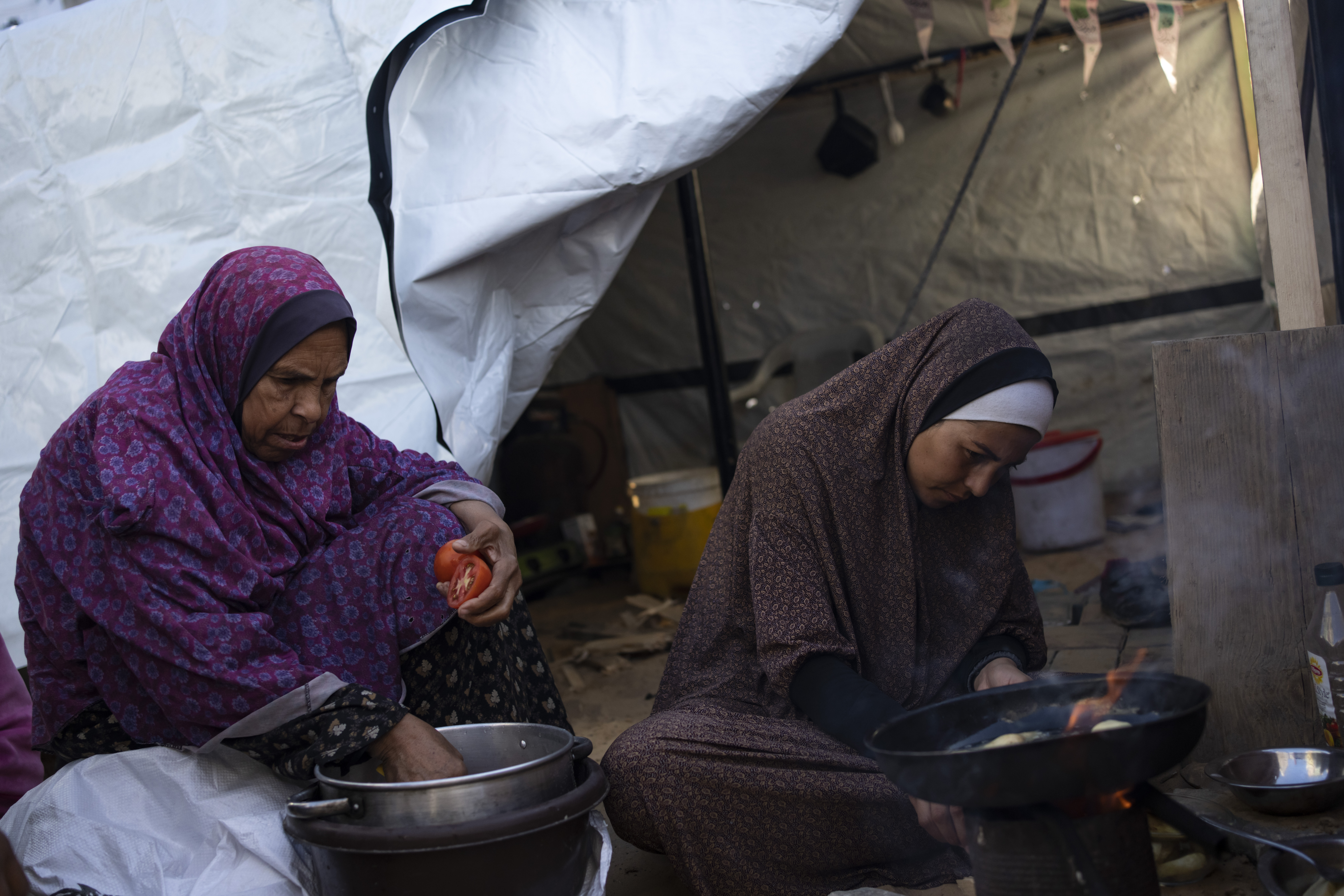 Randa Baker, right, who was displaced by the Israeli bombardment of the Gaza Strip, prepares the Iftar meal with her mother on the first day of the Muslim holy fasting month of Ramadan. Photo / AP