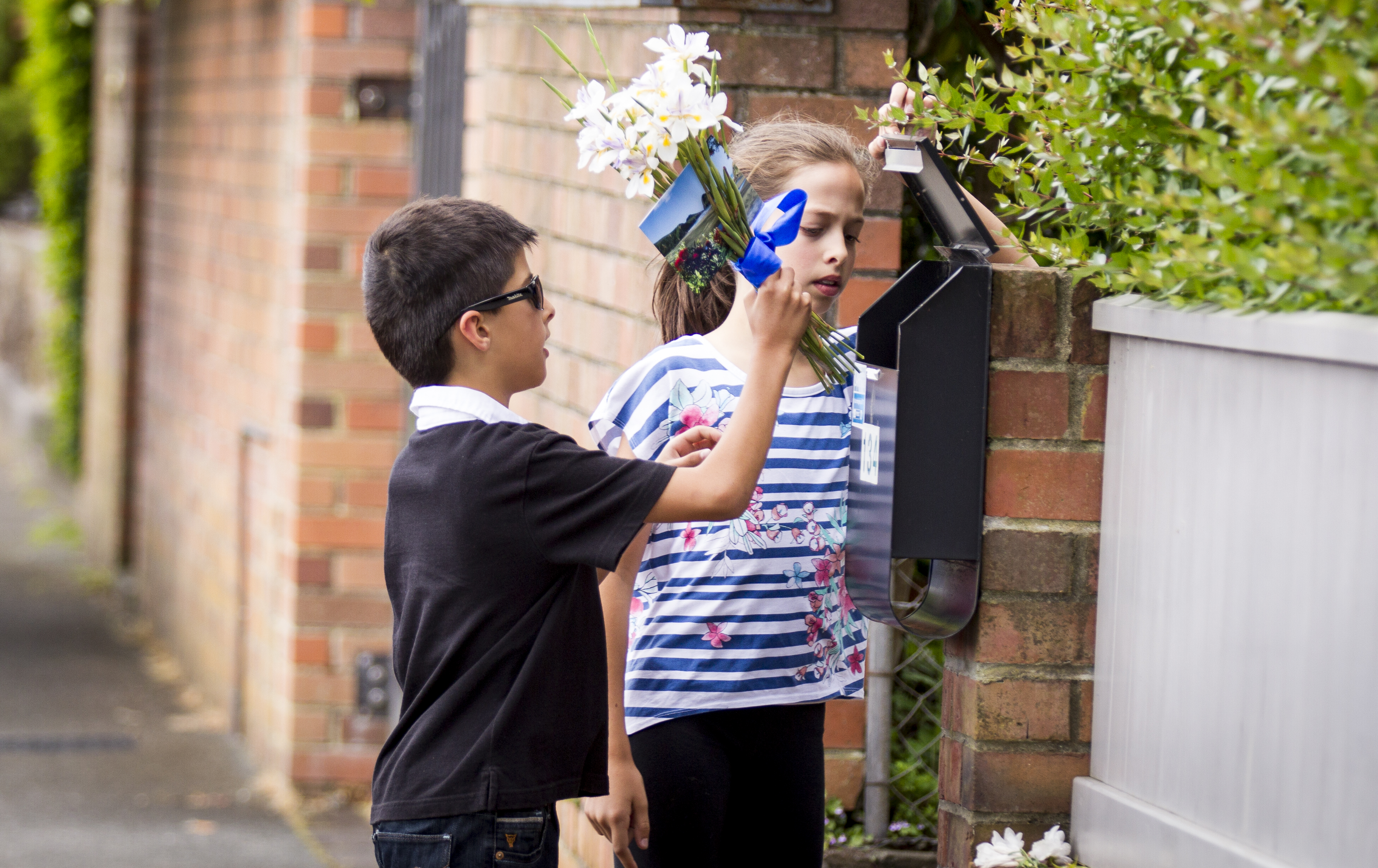 Kids place flowers in the letter box of All Blacks legend Jonah Lomu. Photo / Dean Purcell