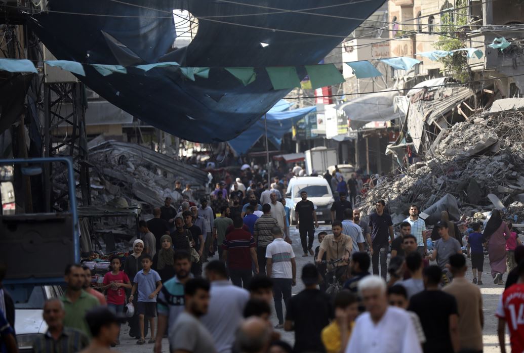 Palestinians walk in the street market of Jabaliya refugee camp, northern Gaza Strip, after an Israeli airstrike. Photo / AP