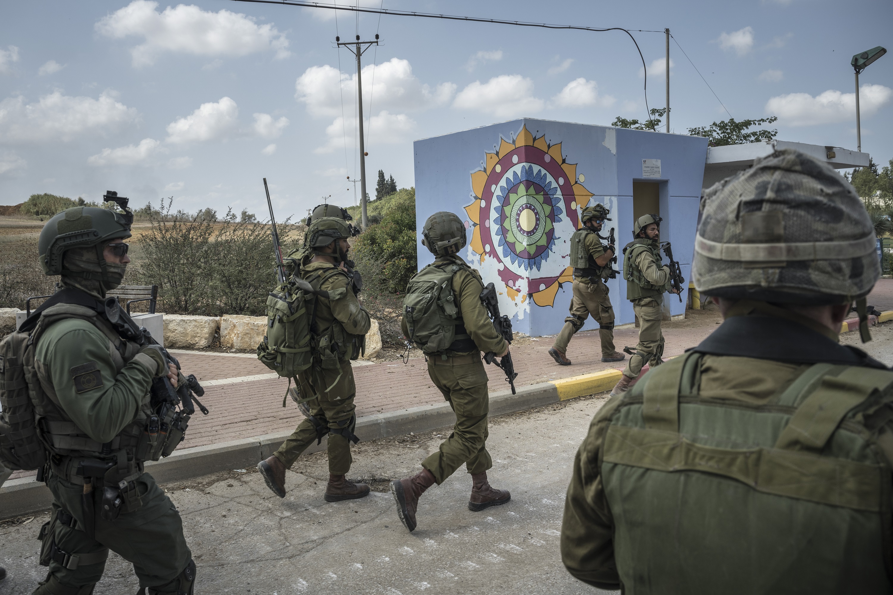 Israeli soldiers gather outside Kfar Azza. Photo / Sergey Ponomarev, The New York Times