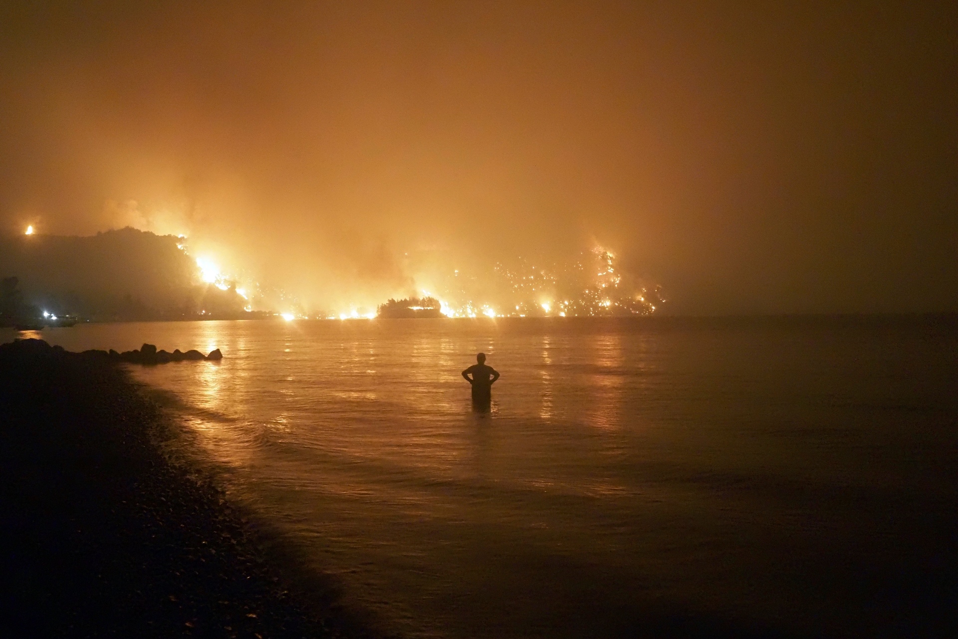 A lone man watches on as wildfires rage near Limni, 160km north of Athens, this month. A new UN report warns that these events are growing more frequent under climate change. Photo / AP