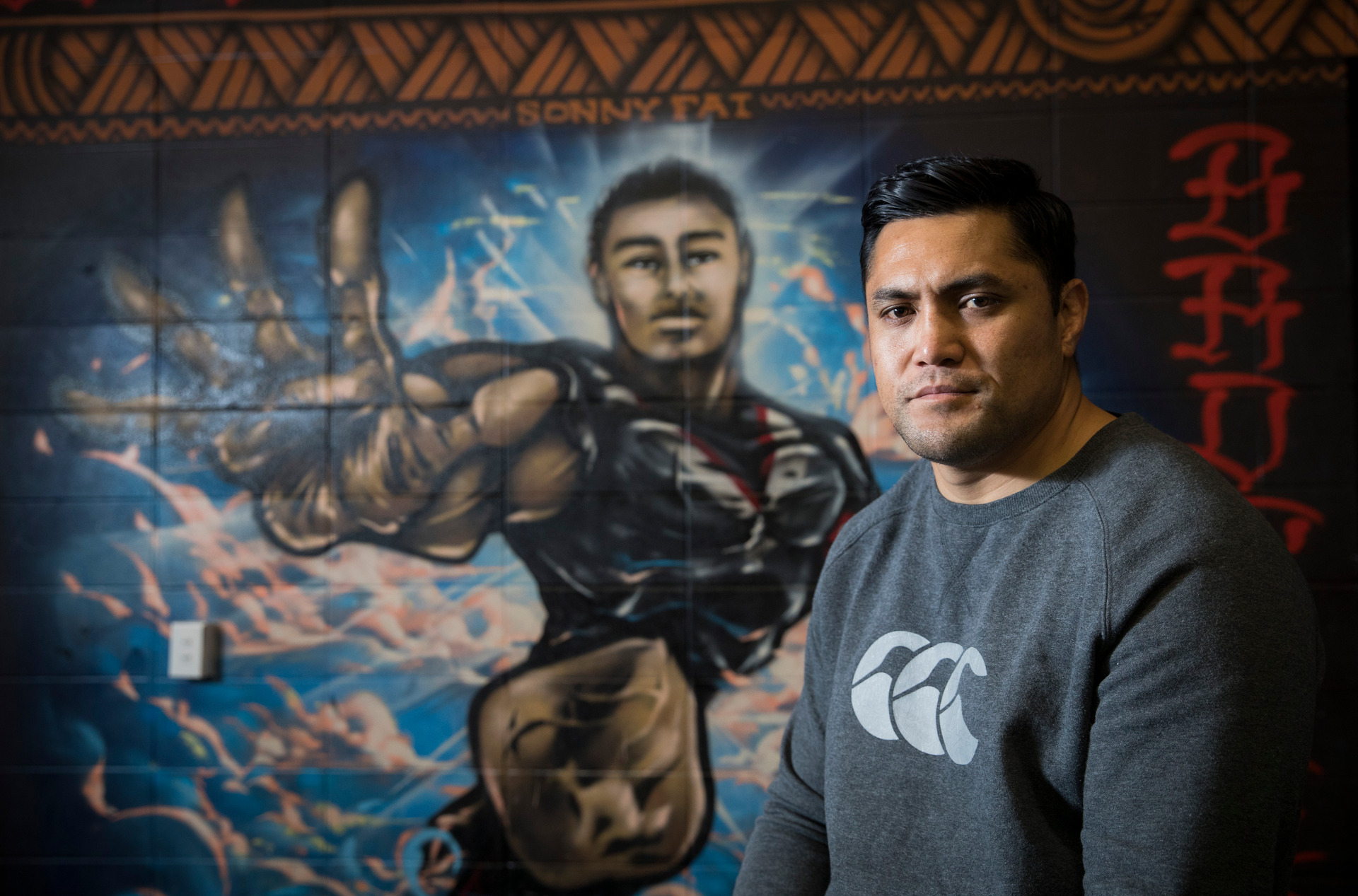 Jerome Ropati in front of a picture of Sonny Fai at Mt Smart Stadium. Photo / Greg Bowker