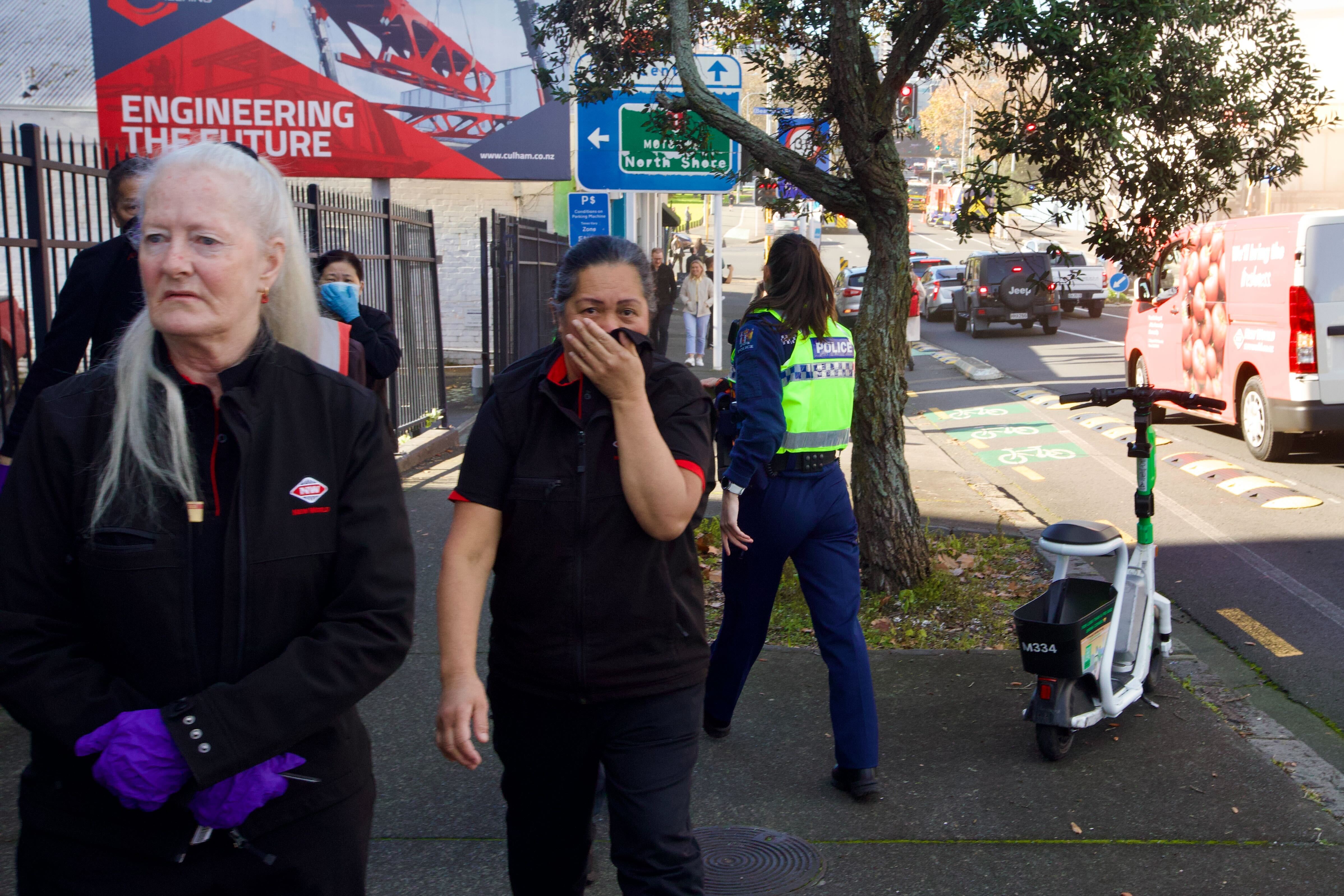 New World workers cover their faces against the smoke as they leave the Victoria St supermarket. Photo / Jason Dorday