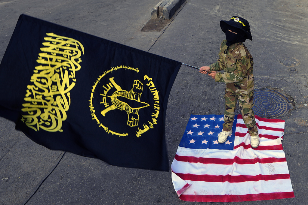A child waves the Palestinian Islamic Jihad group flag while standing on a US flag during a protest at a refugee camp in Beirut, Lebanon. Photo / AP 