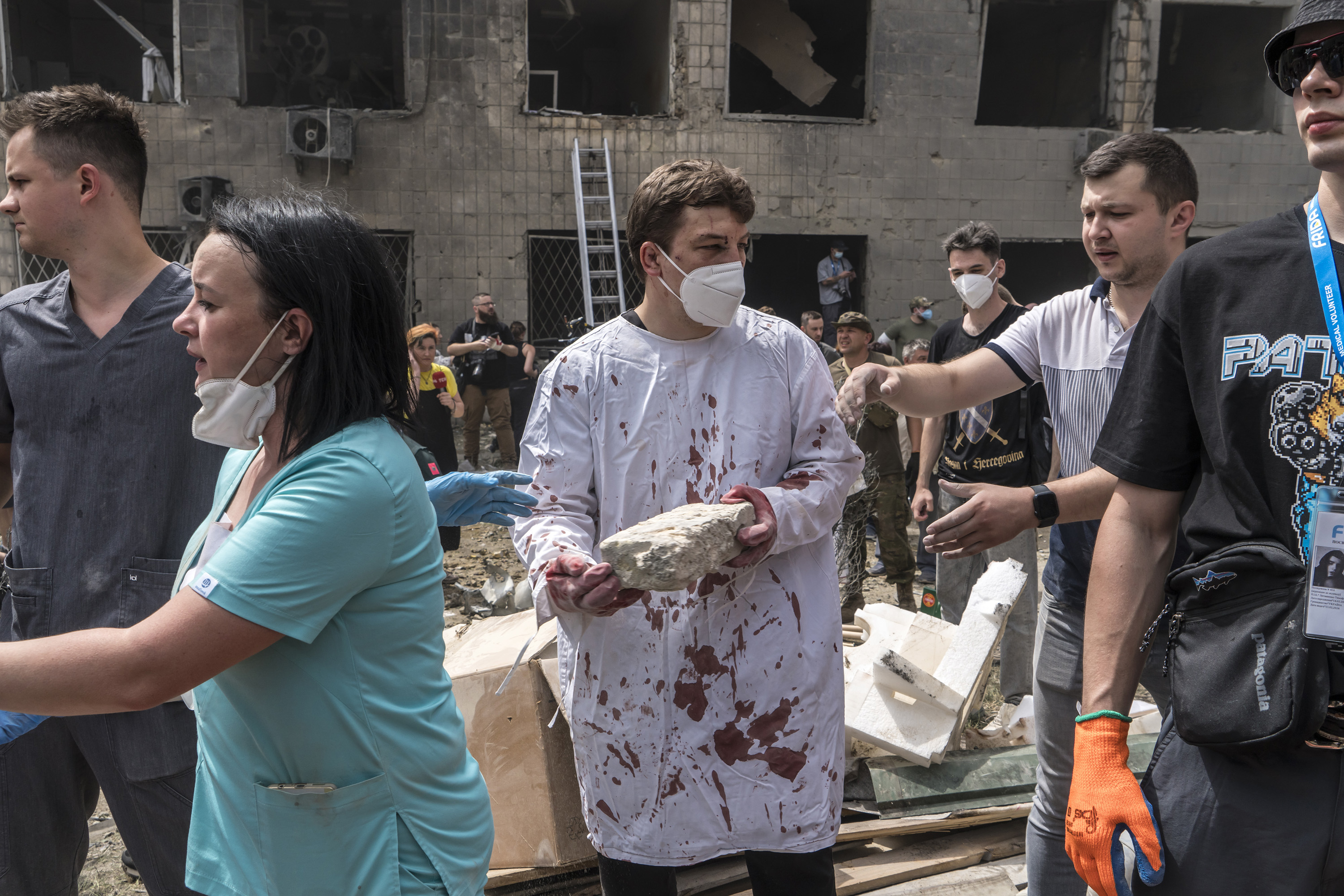 Dr Ihor Kolodka, centre, covered in his own blood, helps others clear rubble after a Russian missile strike on the Ohmatdyt Children's Hospital in Kyiv, Ukraine. Photo / Brendan Hoffman, The New York Times