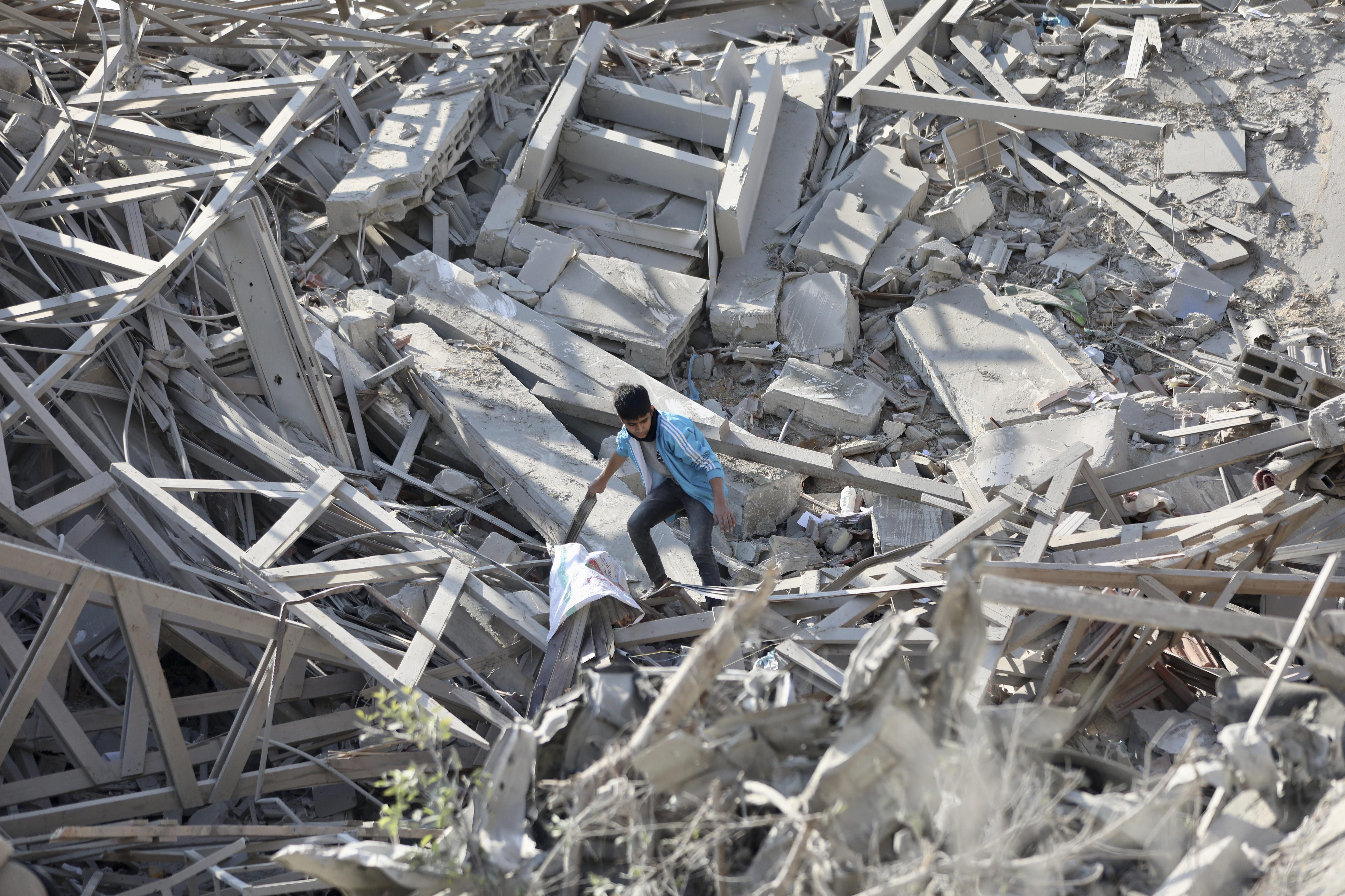 Palestinians walk through the destruction left by the Israeli air and ground offensive on the Gaza Strip in Gaza City. Photo / AP