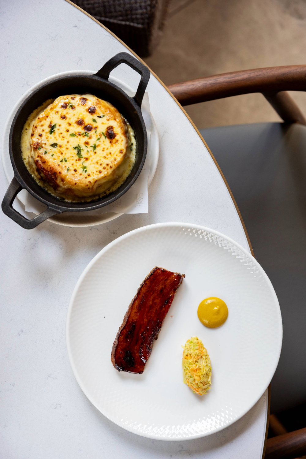 The Grill's 'cured bacon' dish and cheese souffle. Photo / Babiche Martens