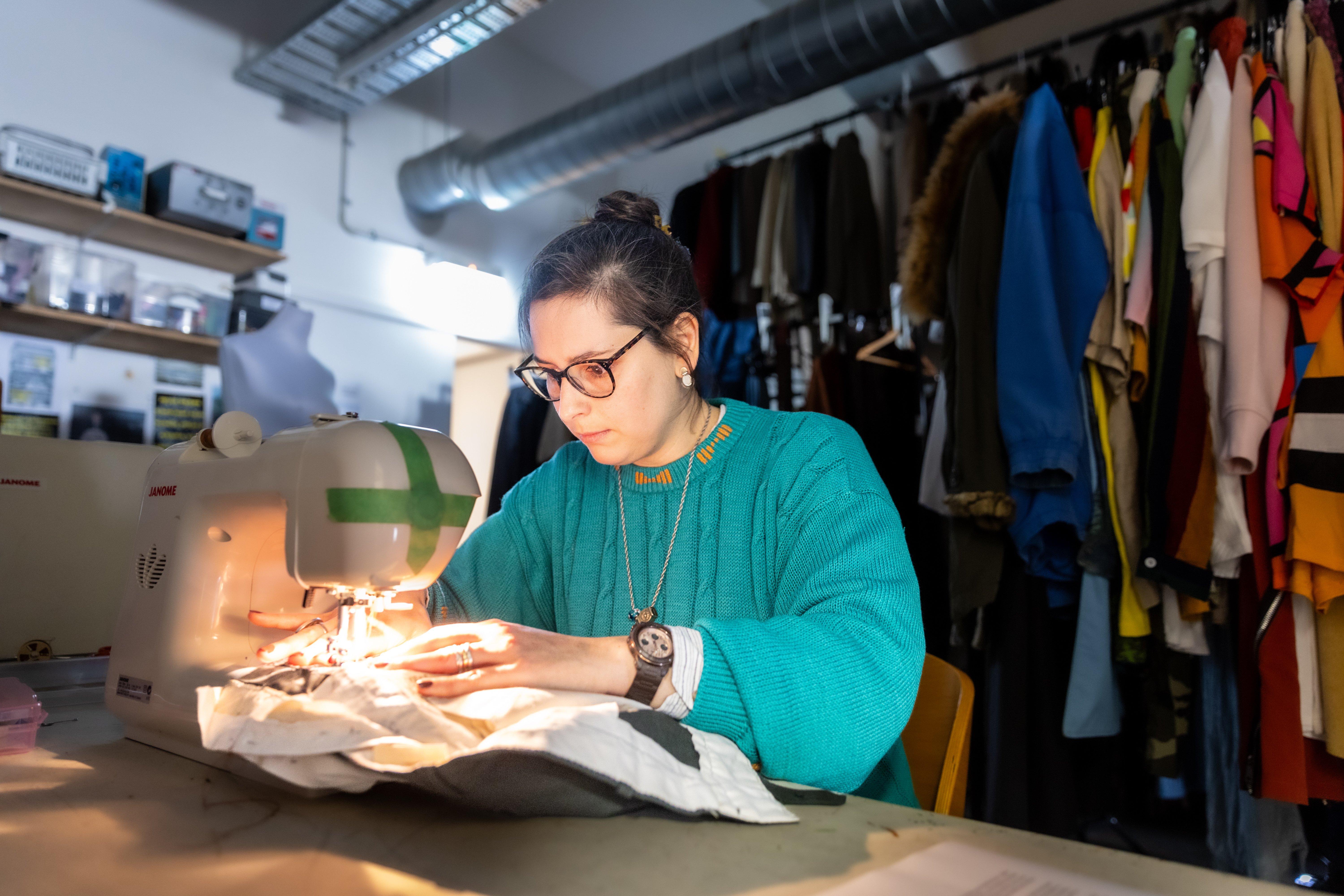 Nati Pereira, spatial and costume designer for Scenes from the Climate Era, tailors a thrifted pair of pants in the costume archive of Auckland Theatre Company. Photo / Michael Craig