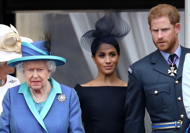 Queen Elizabeth II, Prince Harry, Duke of Sussex and Meghan, Duchess of Sussex on the balcony of Buckingham Palace as the royal family attend events to mark the Centenary of the RAF on July 10, 2018, in London, England.