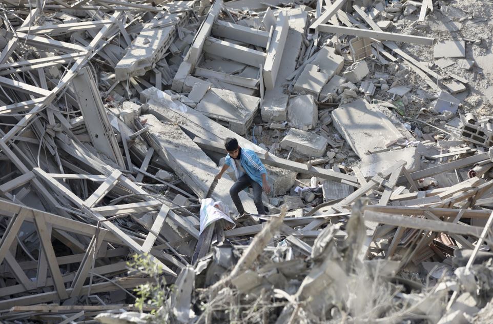 Palestinians walk through the destruction left by the Israeli air and ground offensive on the Gaza Strip in Gaza City. Photo / AP