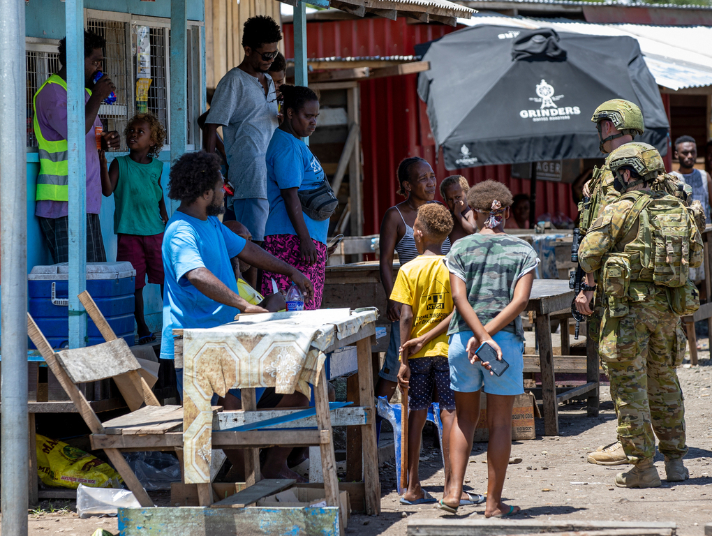 Australian Army soldiers talk with local citizens during a community engagement patrol through Honiara, Solomon Islands. Photo / Australia Defence Force via AP