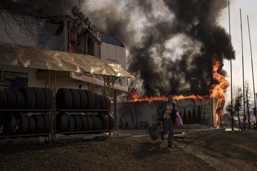 A man recovers items from a burning shop following a Russian attack in Kharkiv, Ukraine on March 25. Photo / AP