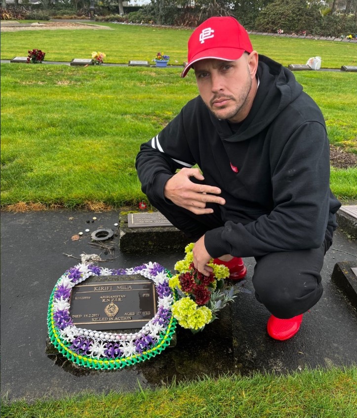 Shane Anderson on a previous visit to the grave of Kirifi Mila, who died aged 27 in Afghanistan. The hand signal denotes 2/1 -  2nd Battalion of the Royal New Zealand Infantry Regiment.