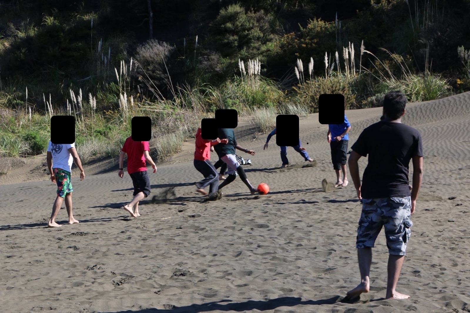 Aathill Samsudeen, with his back to the camera, during a football game at Te Henga. Photo / Supplied