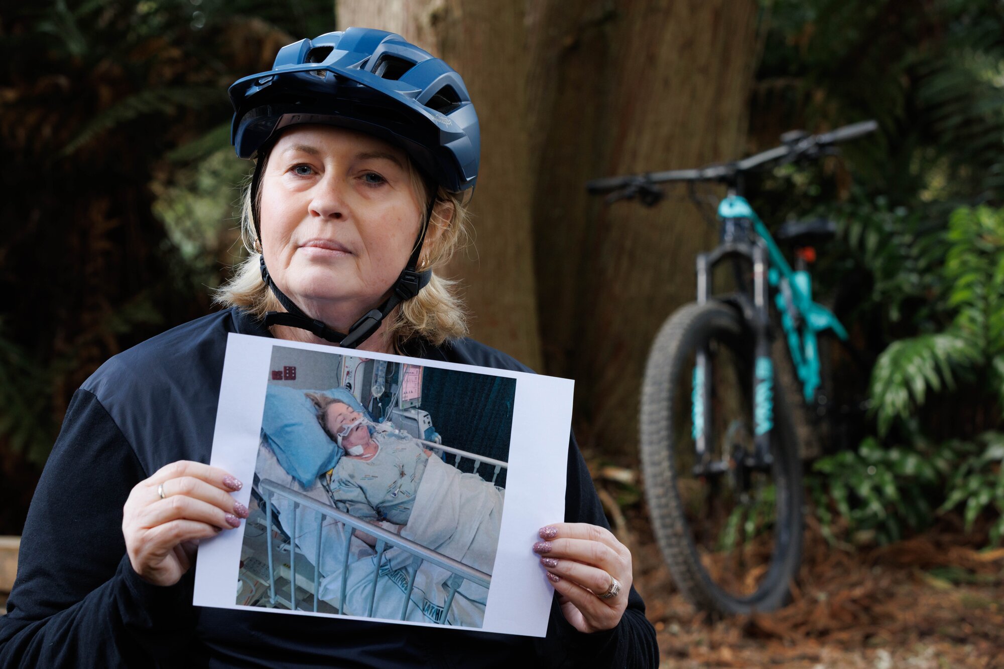 Kath Cross holding a photo of herself in hospital after her lung transplant surgery. Photo / Supplied