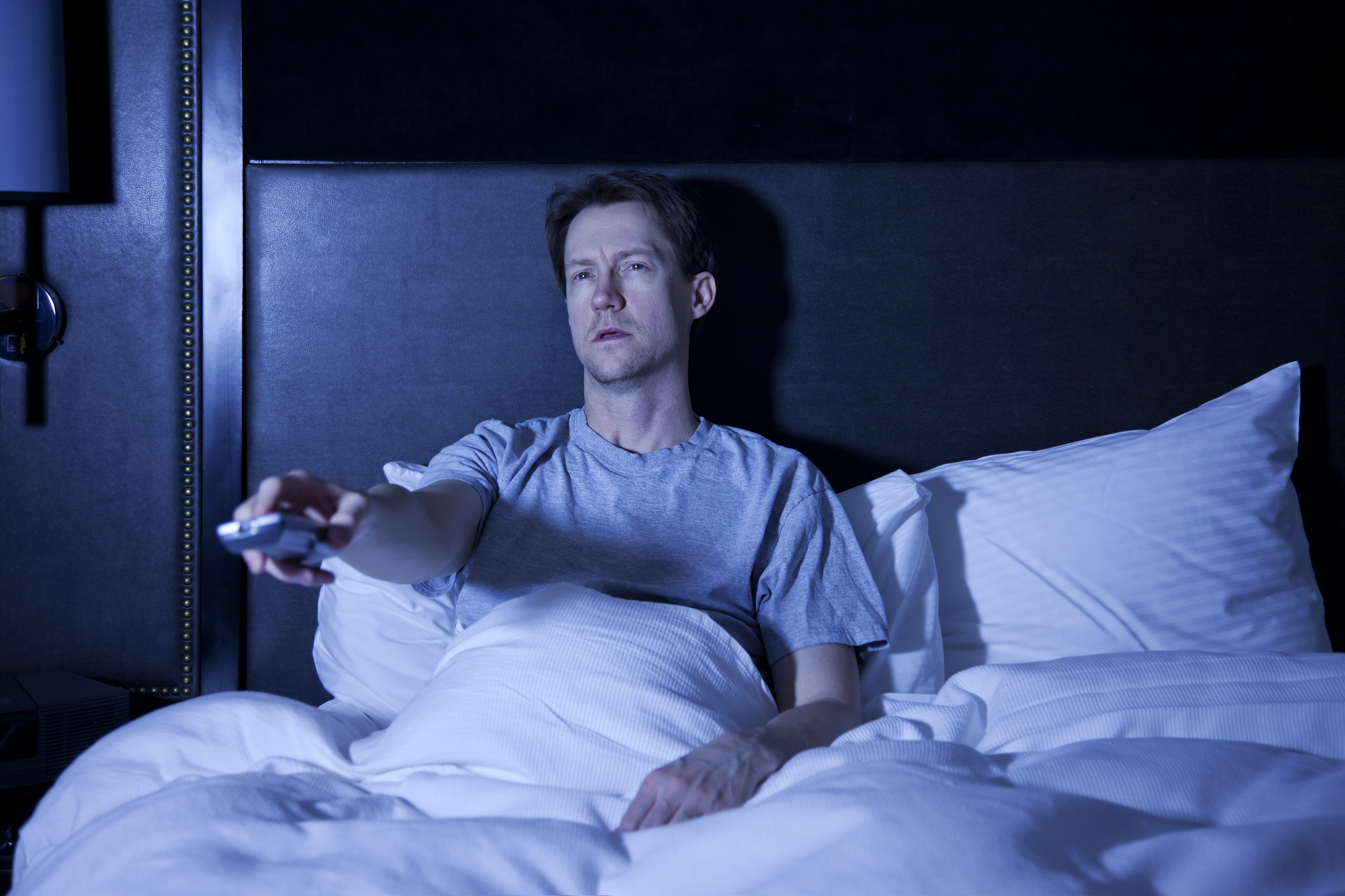 The late-night light and sound from a TV is likely to stimulate your mind and keep you from falling asleep. Photo / Getty Images