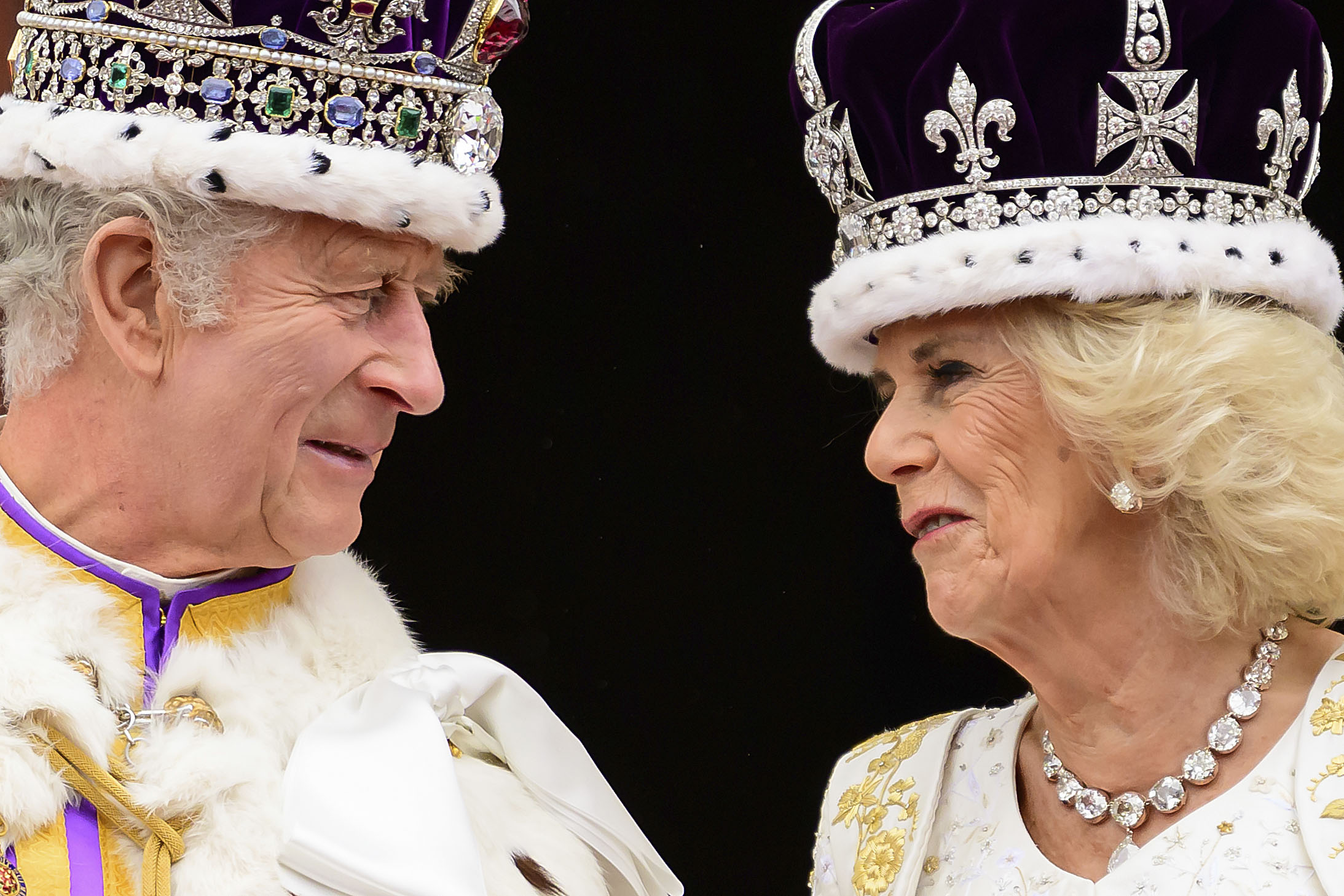 Britain's King Charles III and Queen Camilla look at each other as they stand on the balcony of the Buckingham Palace after their coronation, in London, Saturday, May 6. (Leon Neal/Pool Photo via AP)