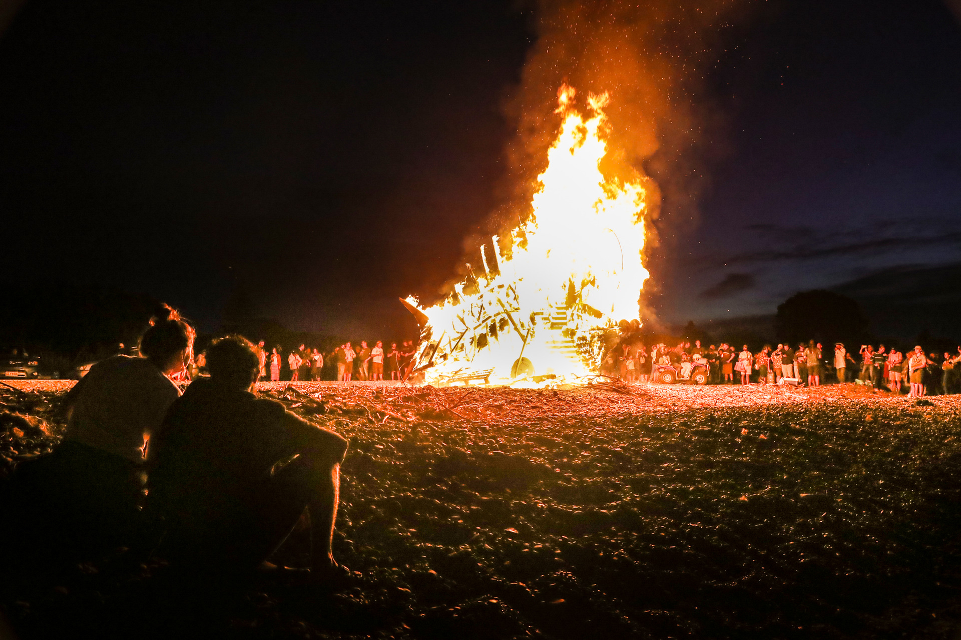 People watch a large fish sculpture burns on the beach at Te Awanga. Photo / Warren Buckland