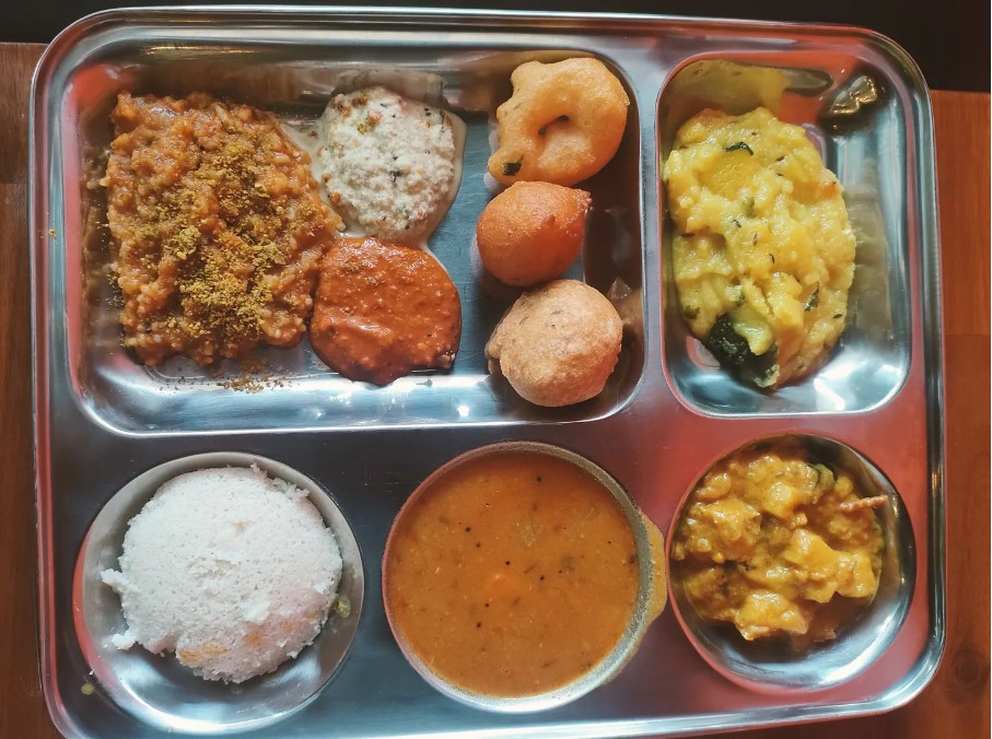 Jesse Mulligan relishes the South Indian breakfast buffet with idli and bisi bele bath at Brown's Bay, complemented by an array of vegetarian delicacies.