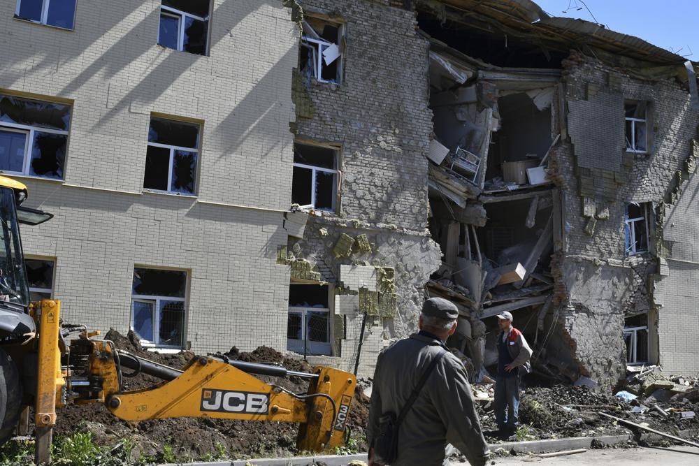 Men stand next to an apartment building damaged by Russian shelling in Bakhmut, Donetsk region. Photo / AP