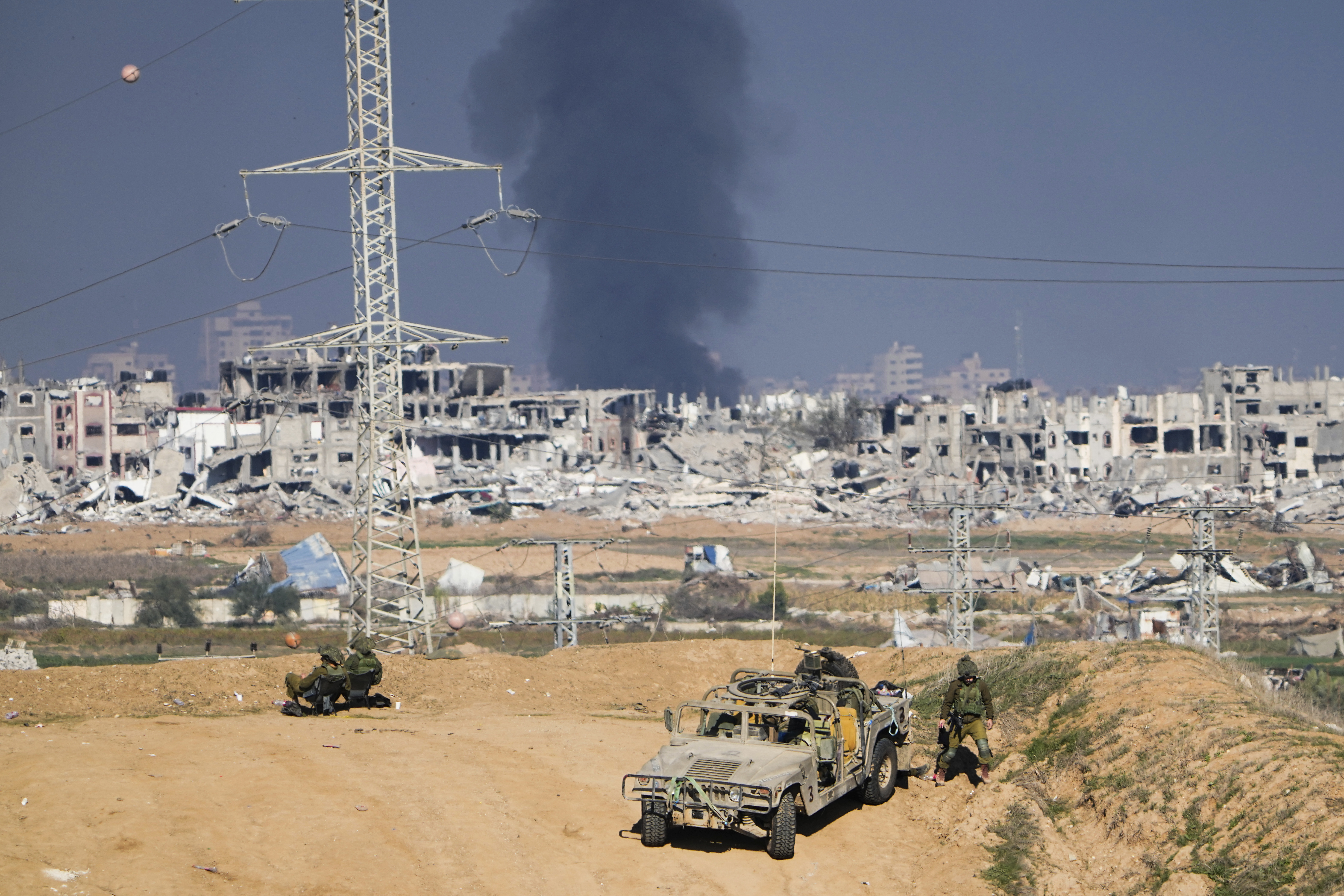 Israeli soldiers take up positions near the Gaza Strip border, as smoke rises following an Israeli airstrike in the Gaza Strip, as seen from southern Israel. Photo / AP 