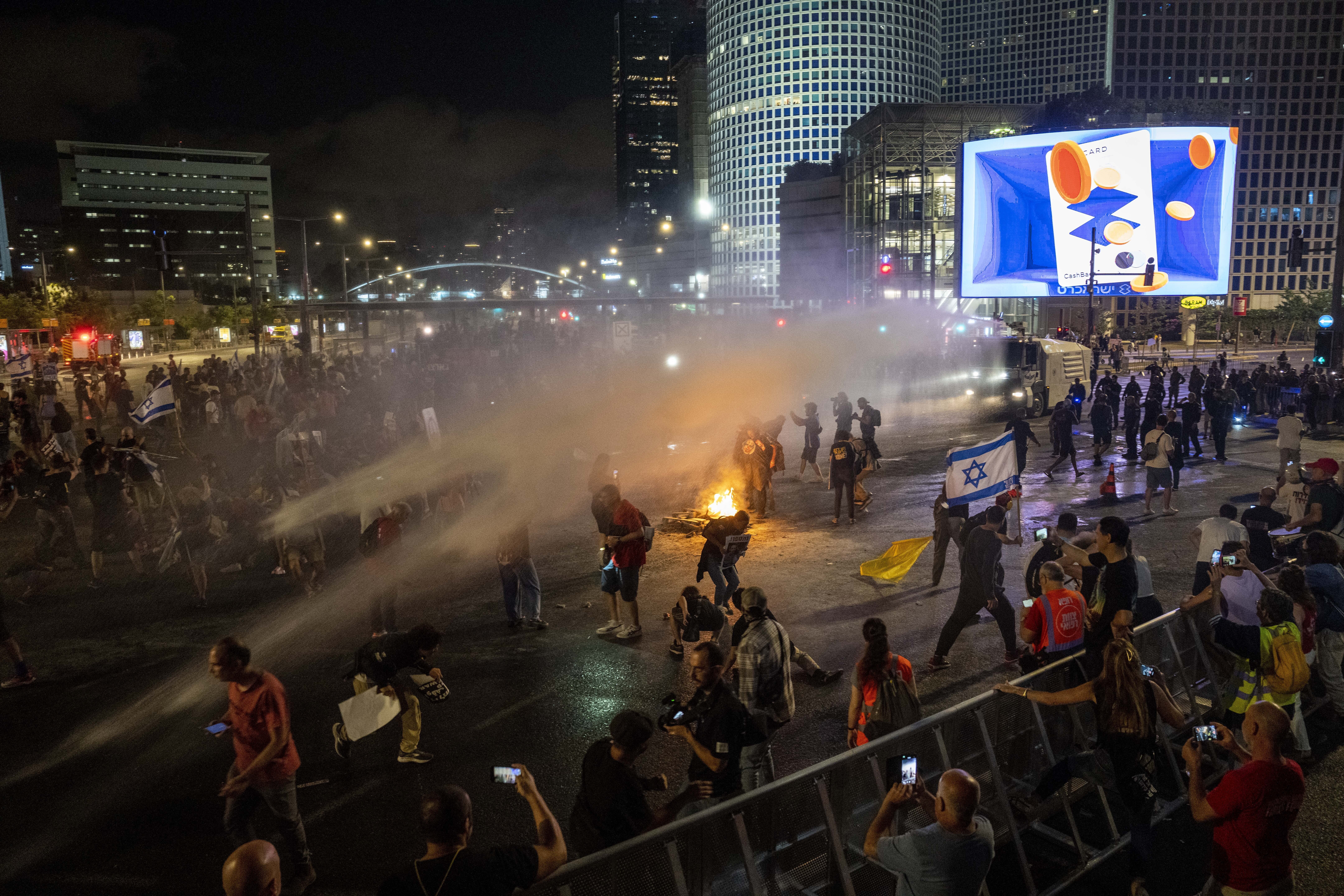 Police use water cannons to disperse demonstrators during a protest against Israeli Prime Minister Benjamin Netanyahu's government. Photo / AP