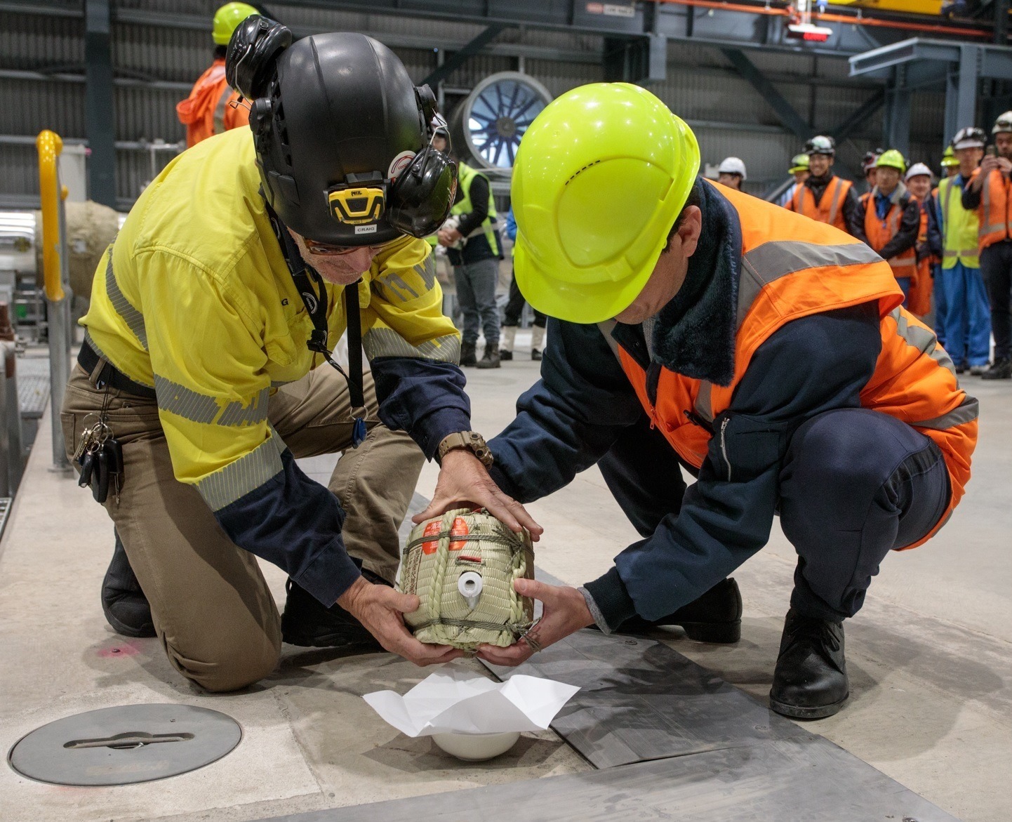 Contact project manager Craig Woolacott and Fuji Electric project engineer Hiroto Fukushima make an offering of sake and salt to cleanse evil spirits at the new Tauhara power station in Taupō.