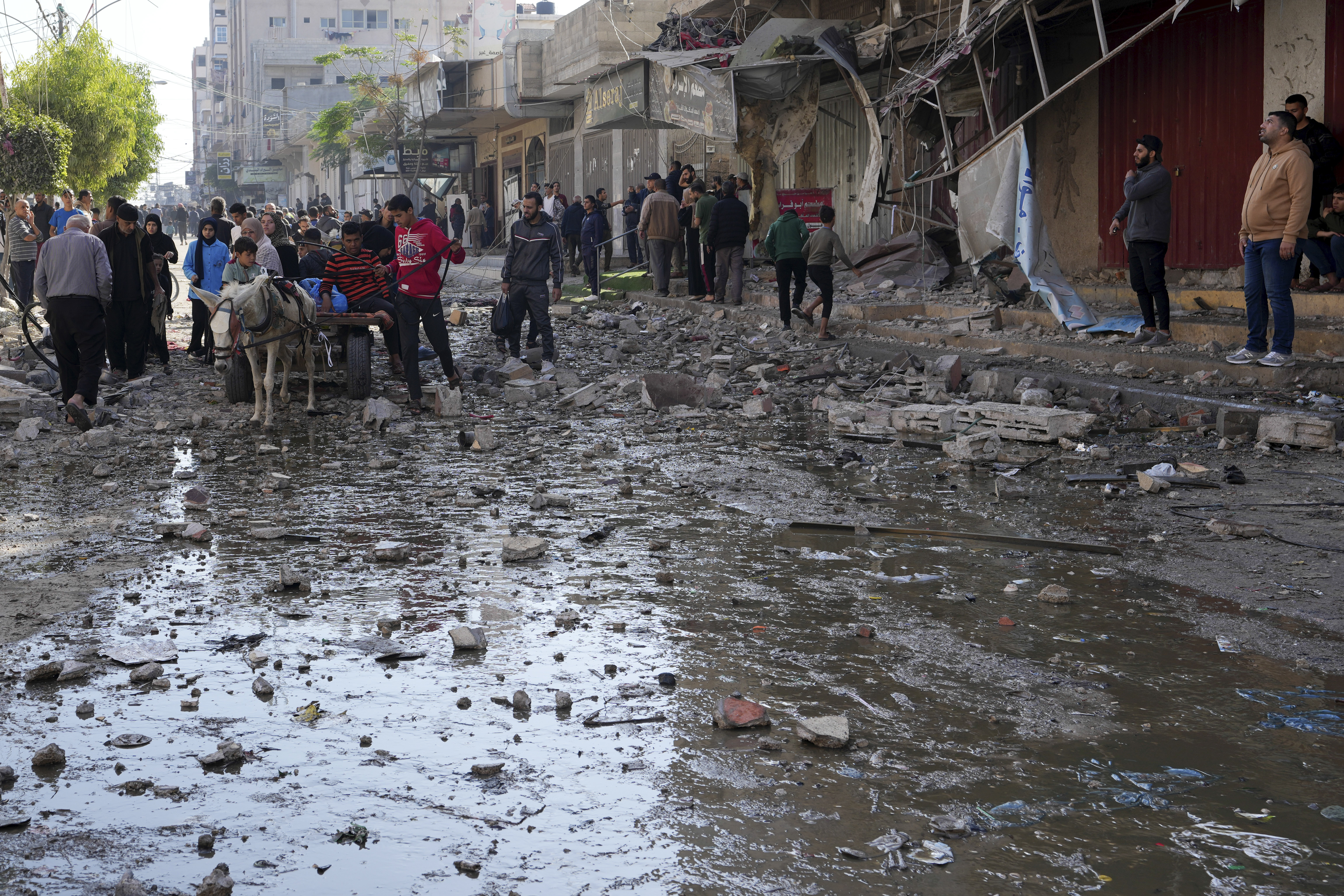 Palestinians gather in front of a building hit by an Israeli airstrike in the Gaza Strip. Photo / AP