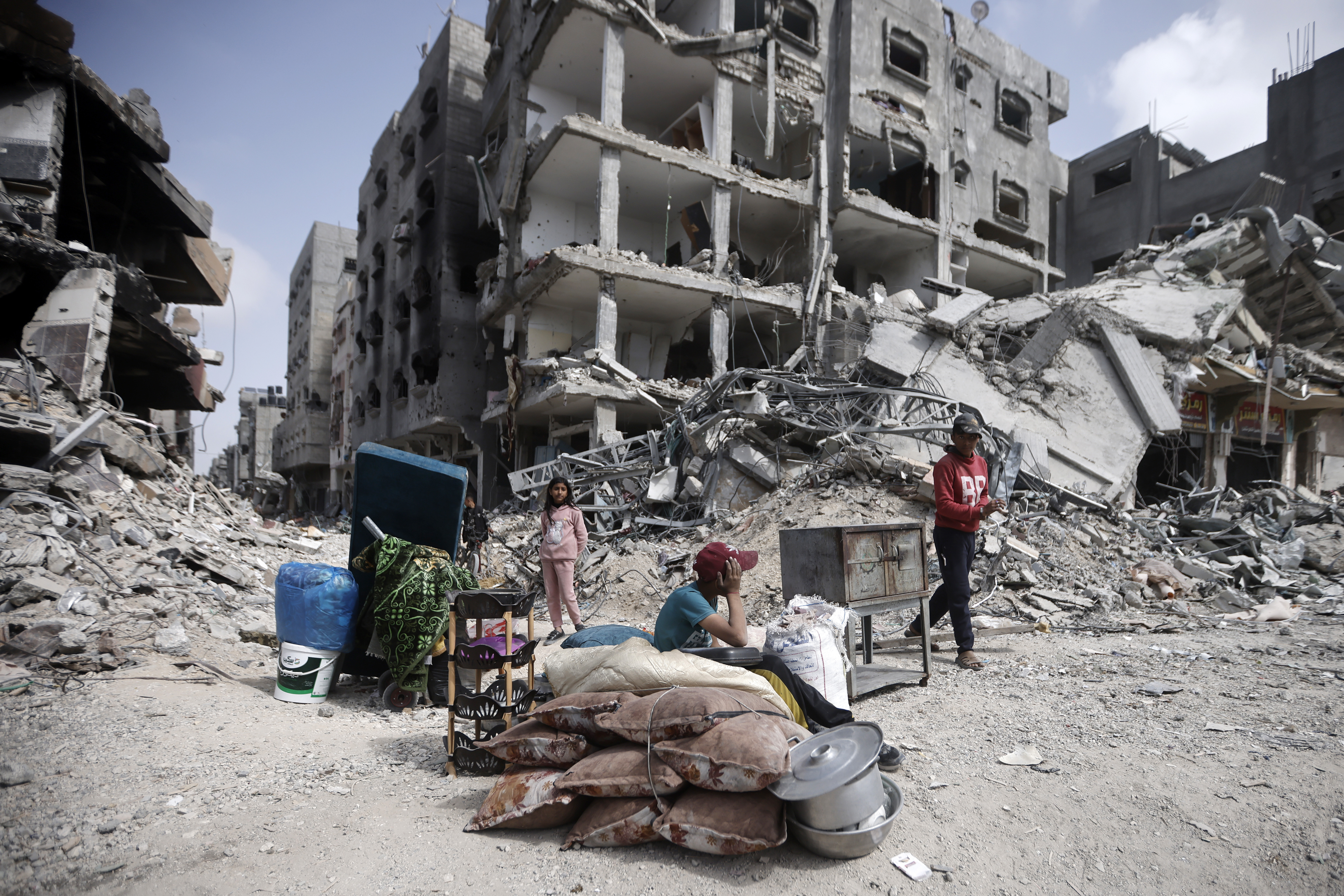 Palestinians sit by their belongings after visiting their homes, destroyed in the Israeli offensive on Khan Younis, Gaza Strip. Photo / AP