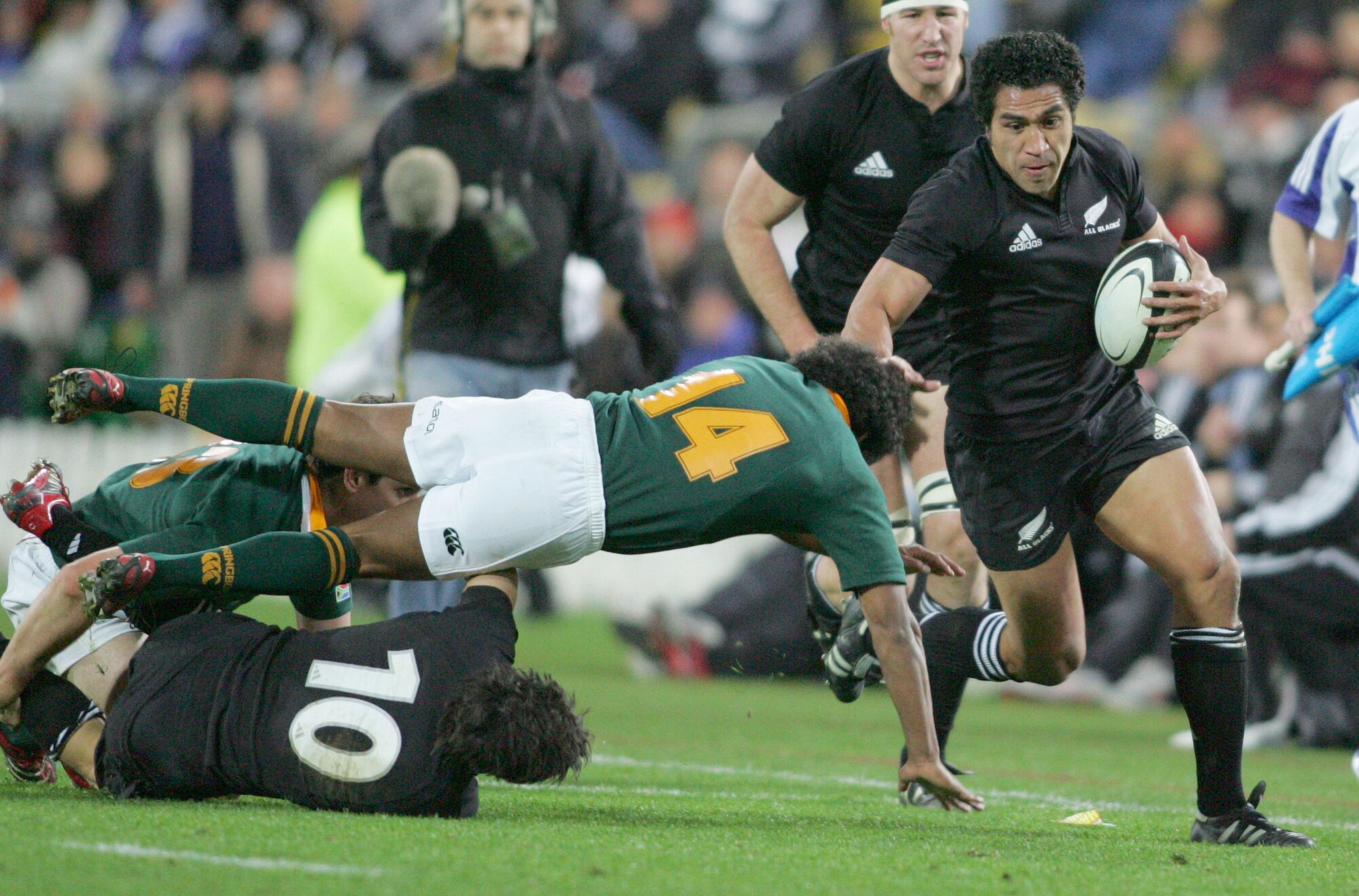 All Blacks centre Mils Muliaina finds space outside the Springboks defenders. Photo / Mark Mitchell