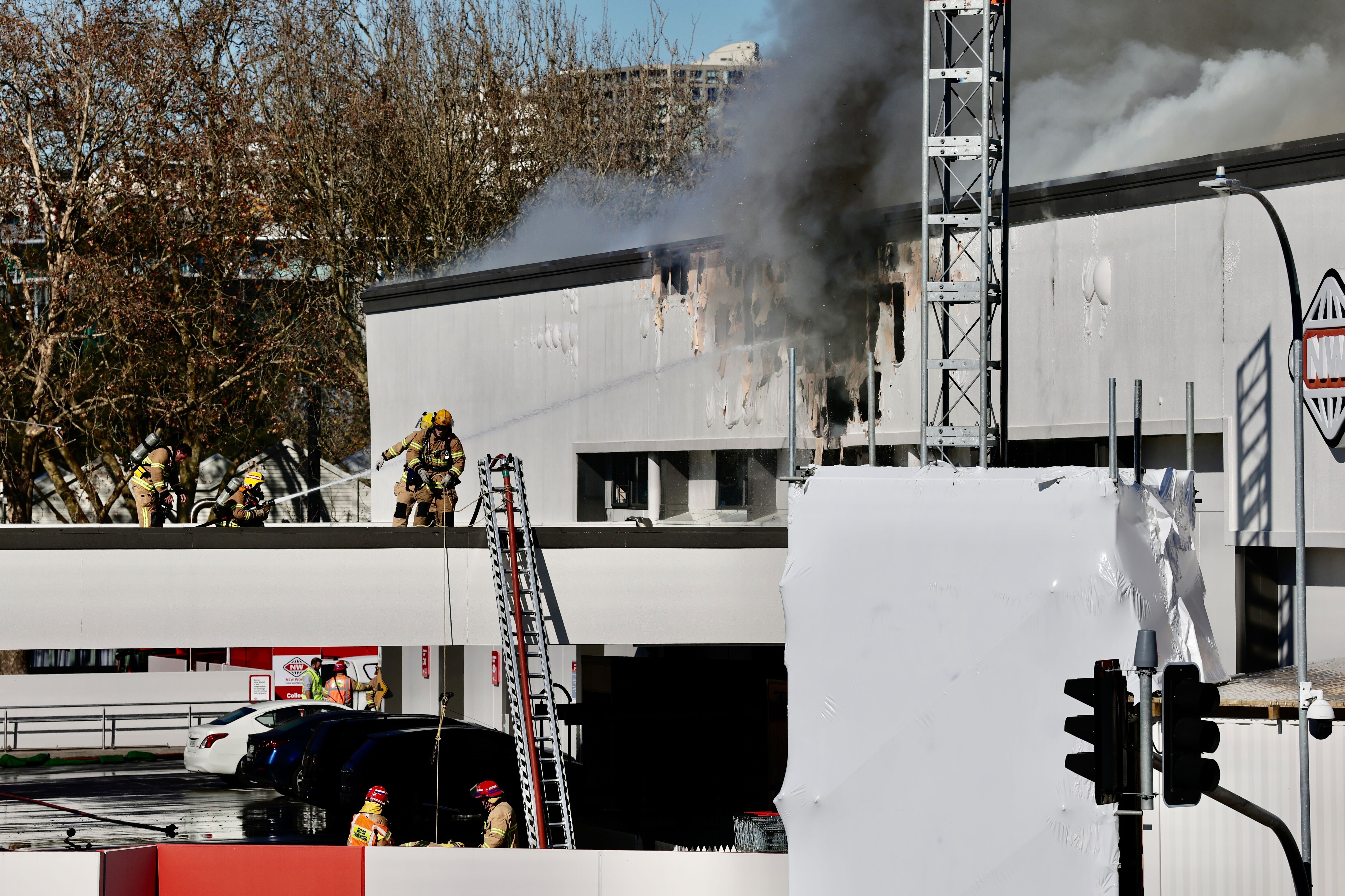 Firefighters attacking the side of the New World building near the roof. Photo / Dean Purcell