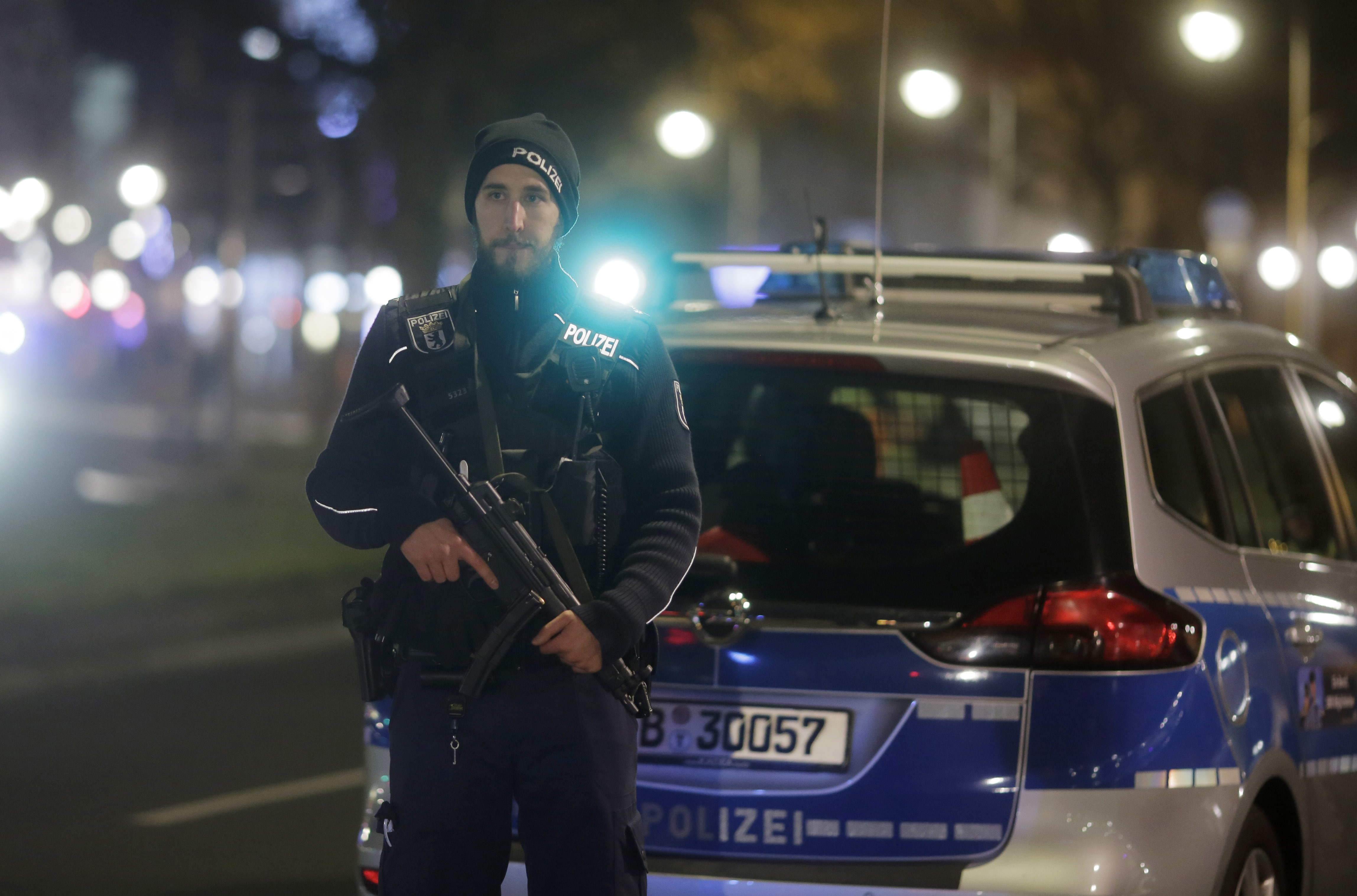 A police officer with a submachine gun stands guard after a truck ran into a crowded Christmas market in Berlin. Photo / AP