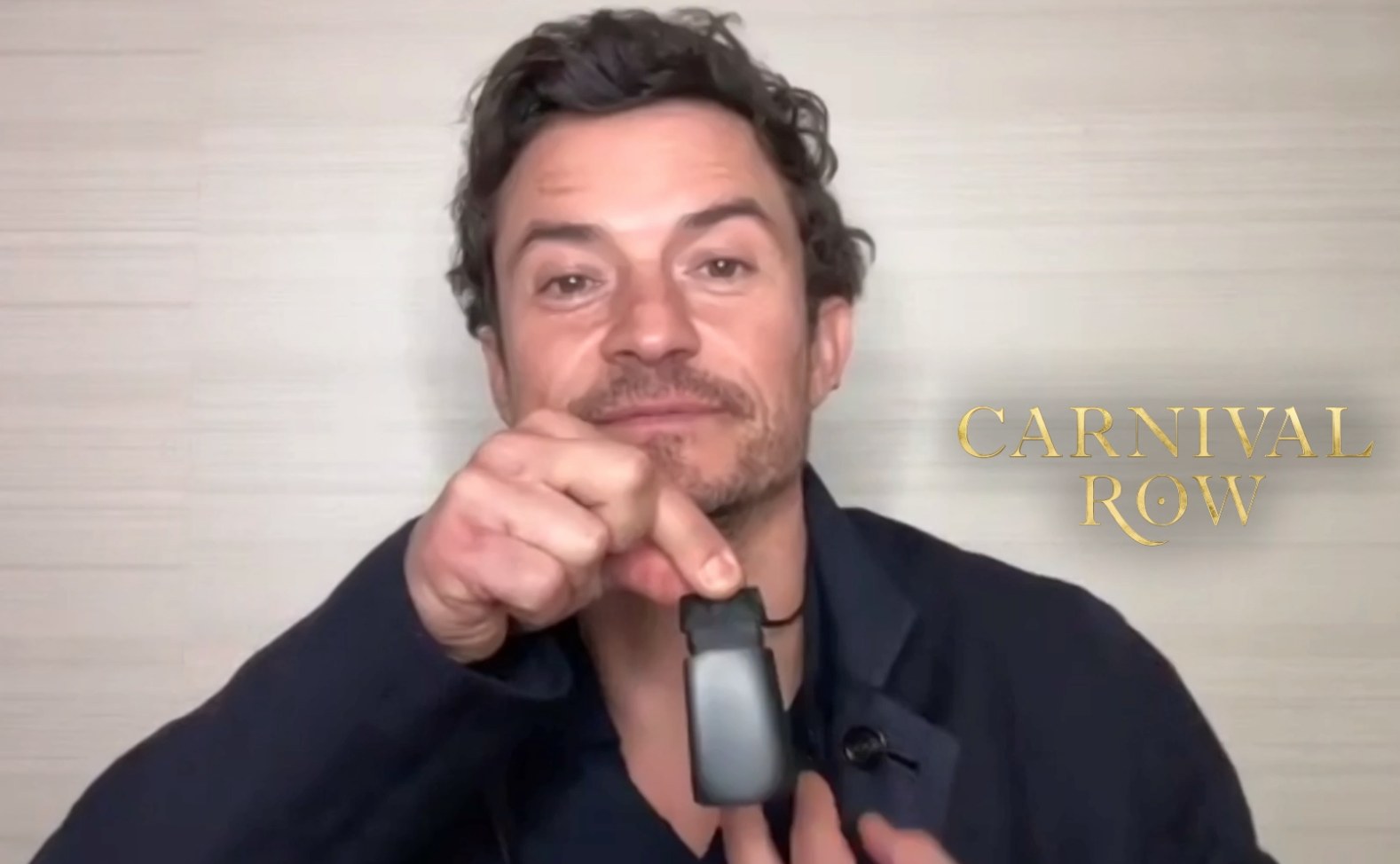 Orlando Bloom showing the taonga he was gifted, during an interview for his new show Carnival Row.